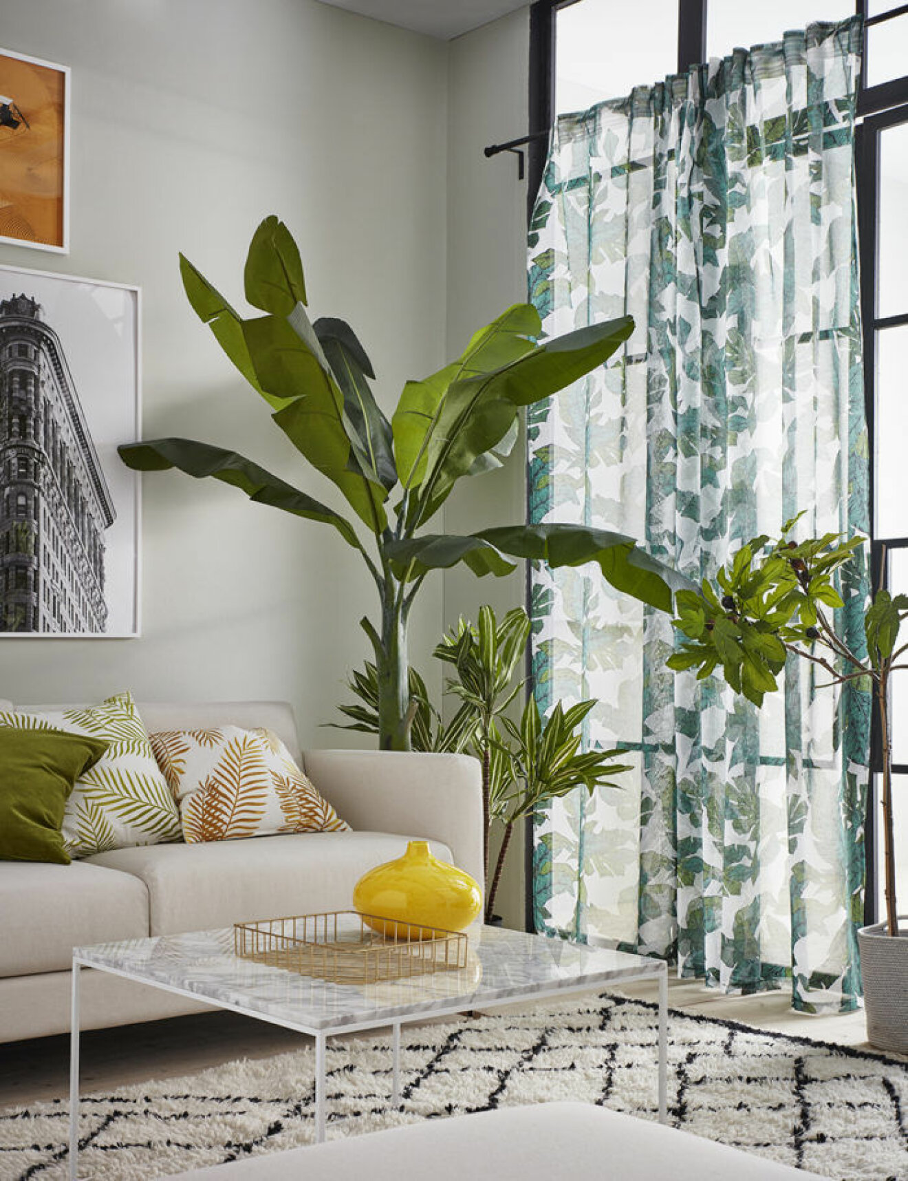 Vardagsrum med bananplanta och fikonträd. Mönstrad matta och gardiner. Jotex vår och sommar 2018. 
