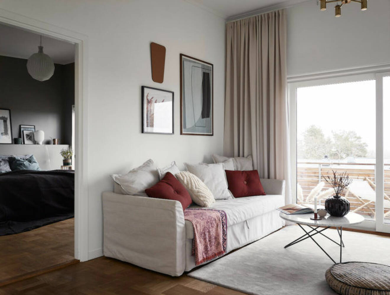 Ljust vardagsrum med gardiner och en mysig soffa