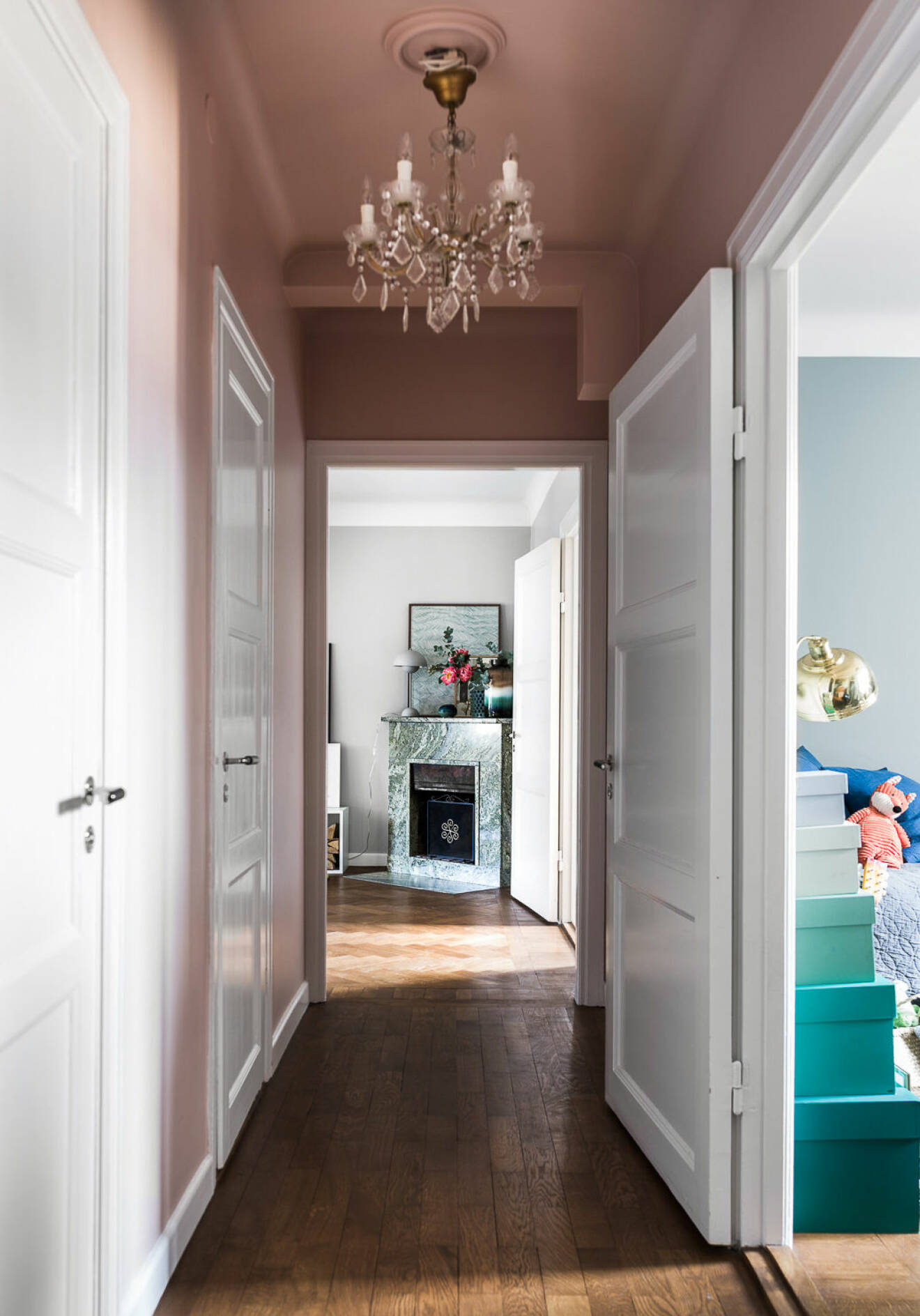 Pink painted ceiling and pink walls in an apartment in Stockholm. Scandinavian styled hallway.