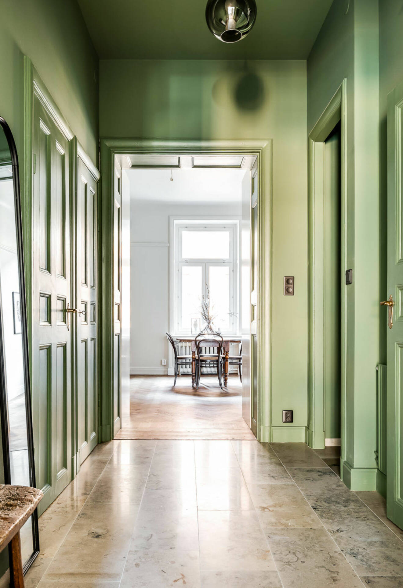 Green painted ceiling and walls in an apartment in Stockholm. Scandinavian styled hallway. 
