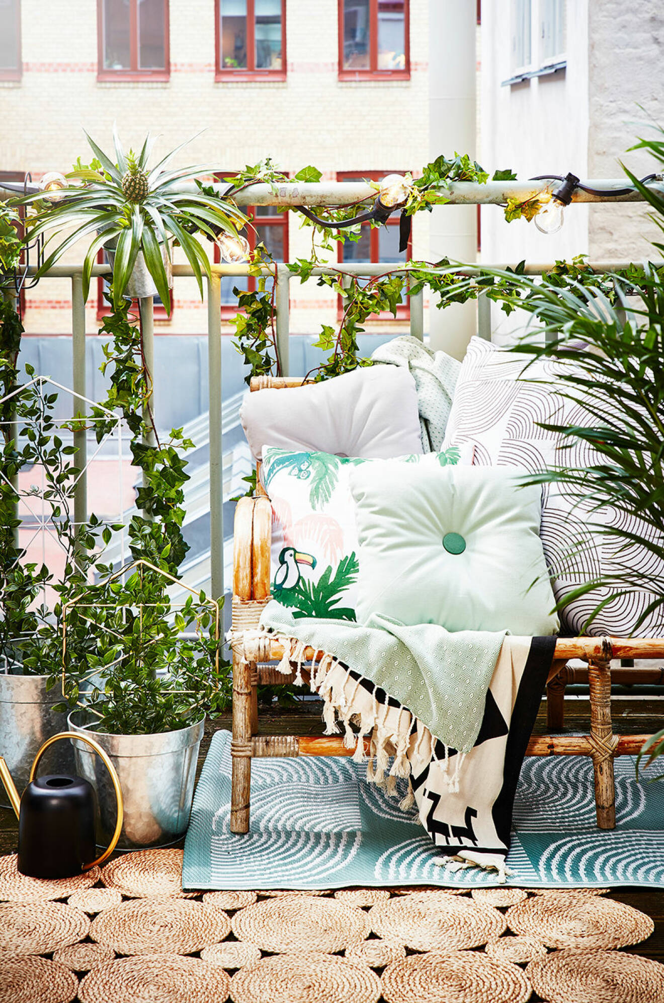 Balkong med bambusoffa, textilier och växter