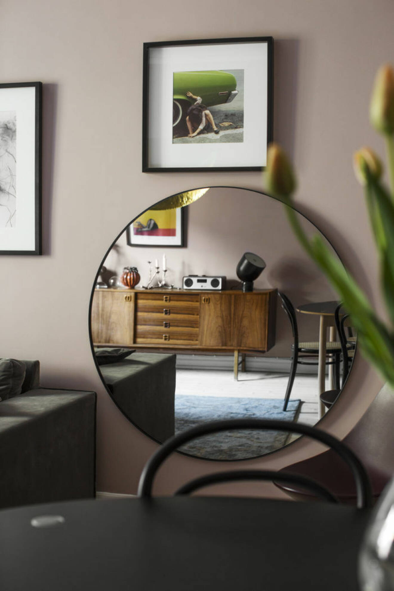 rund spegel i vardagsrummet med reflektion från sidobordet