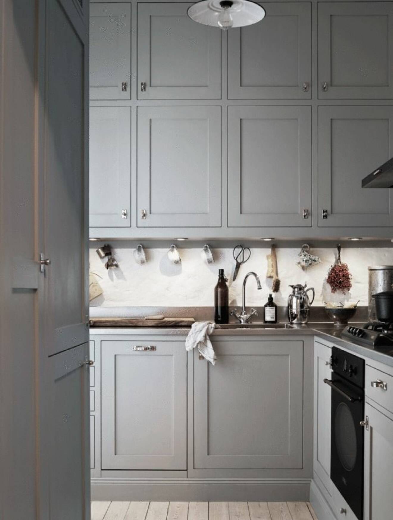 Stilrent grått kök med platsbyggda köksskåp