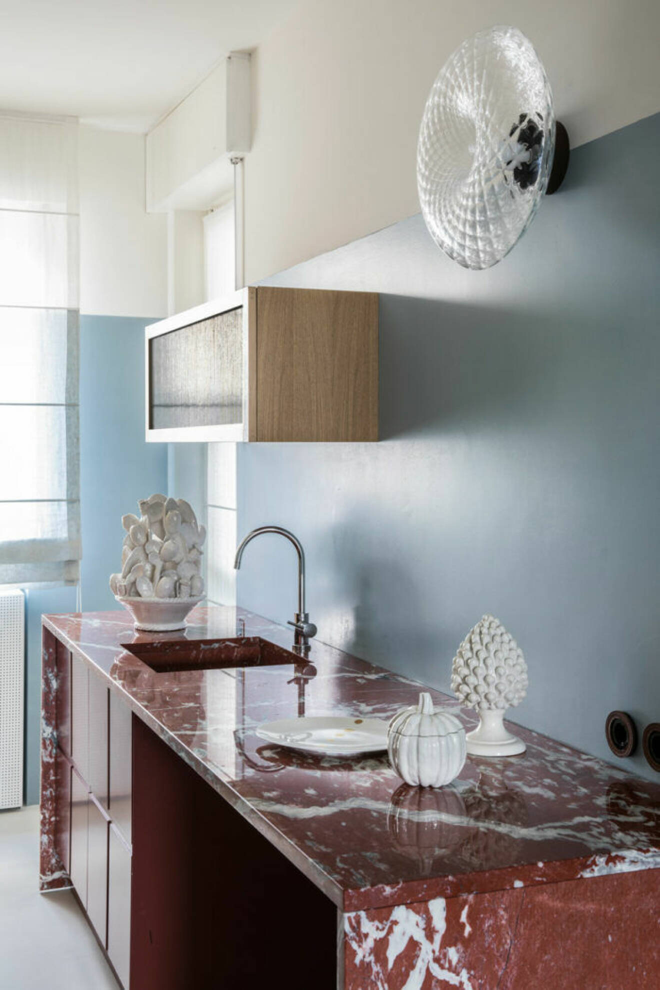 Ljusblått kök med röd marmor
