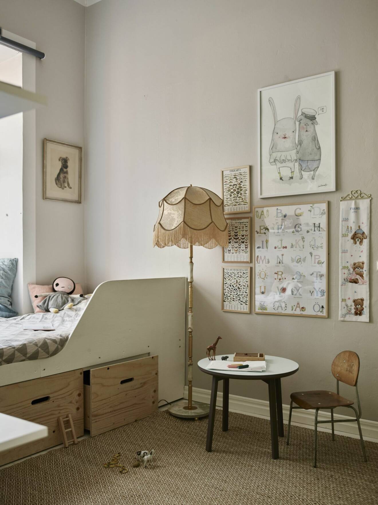 Ljusmålat barnrum med tavelvägg, förvaring och platsbyggd säng