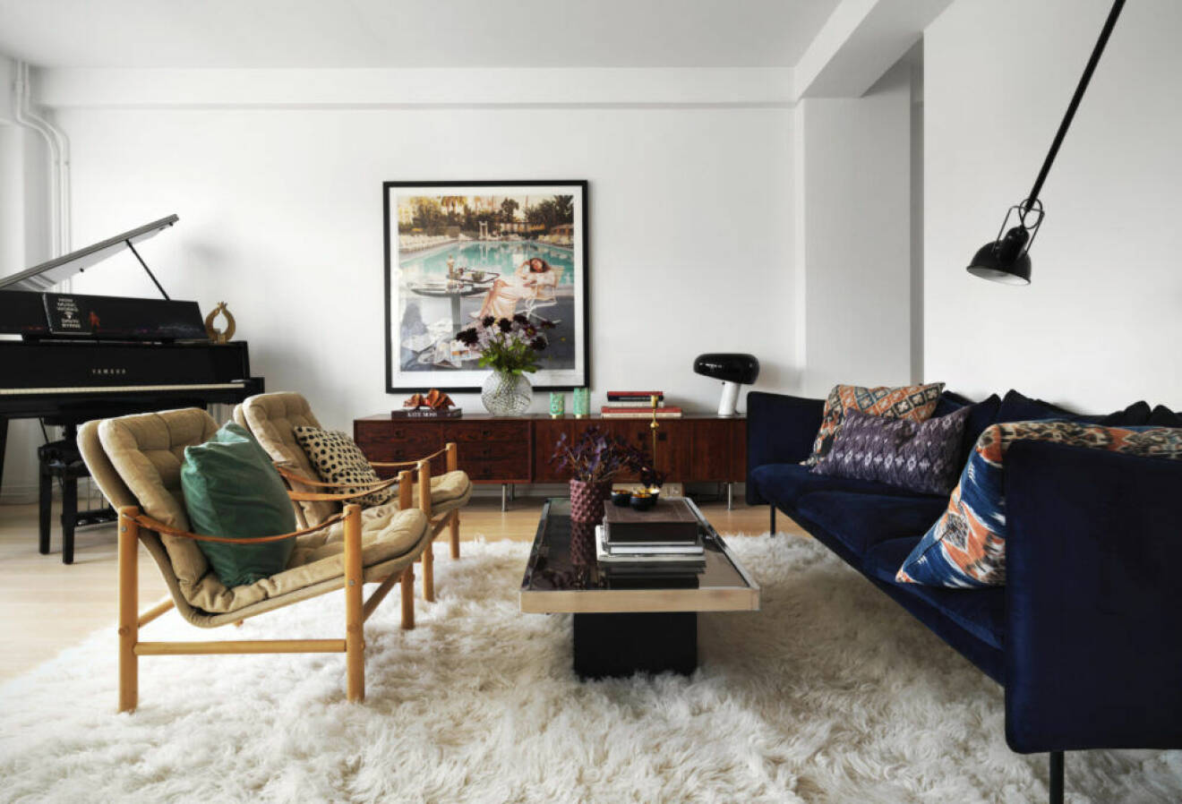 Vacker flygel, vit fluffig matta och färgglada möbler i vardagsrummet