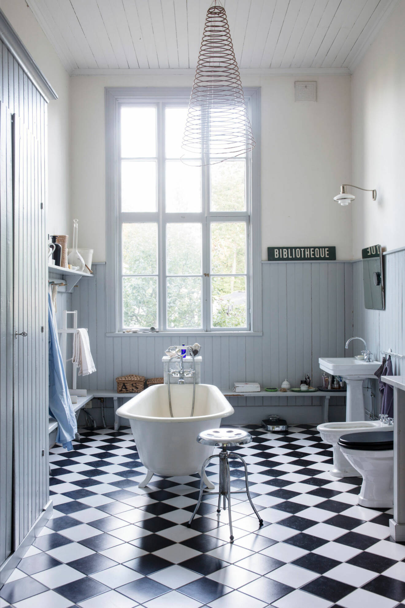 Badrummet har svartvitrutigt golv och väggar i vita och ljusblåa toner