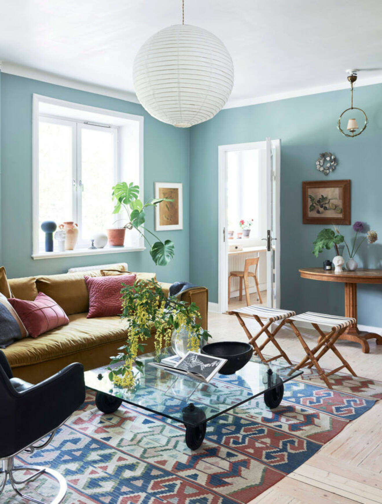 Vardagsrummet går i ljusblåa toner med detaljer i brunt, rosa och trä