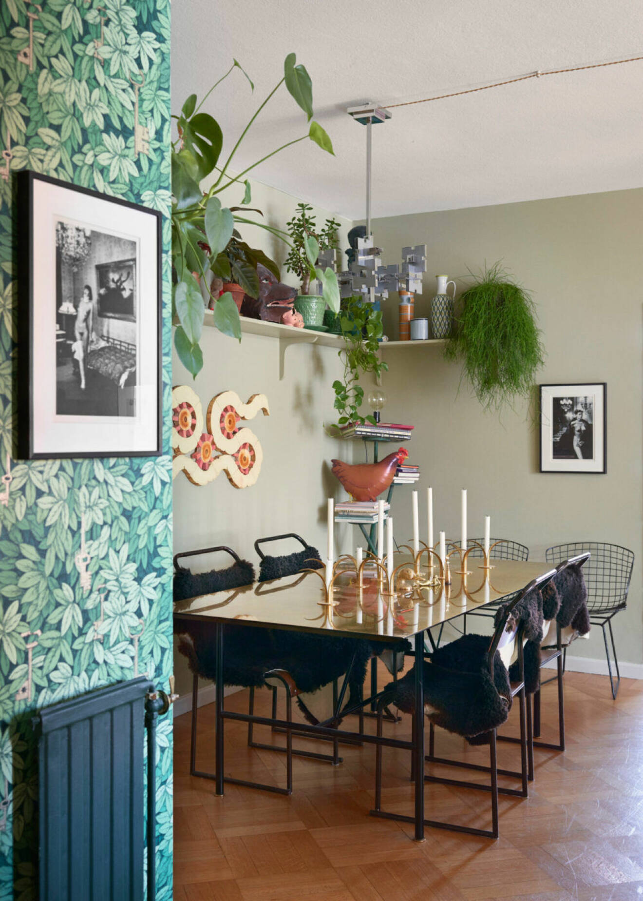 Matplats med mycket växter, mönstrad tapet och svarta möbler hos Ursula Wångander