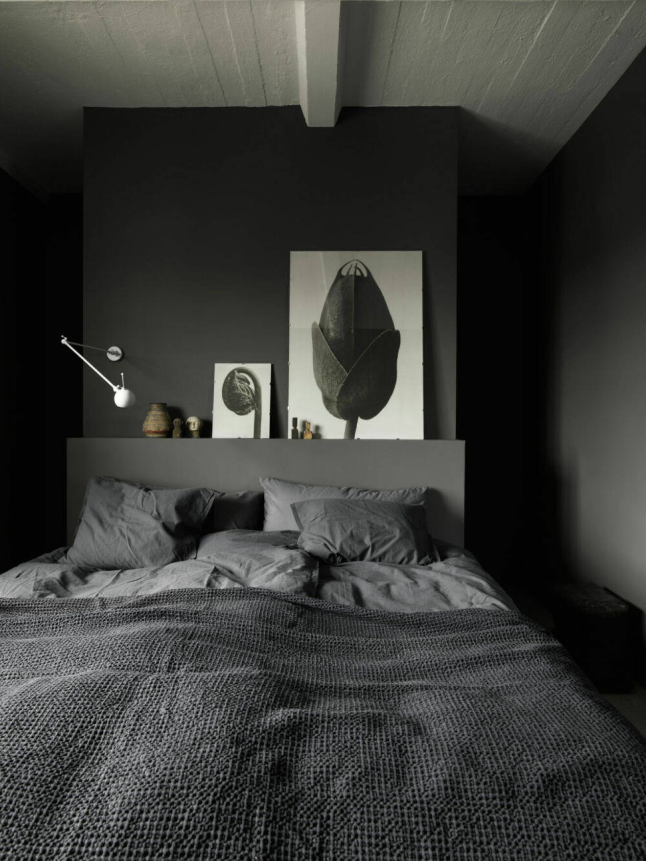 Sovrum med gråa väggar och gråa textilier i Tulohuset