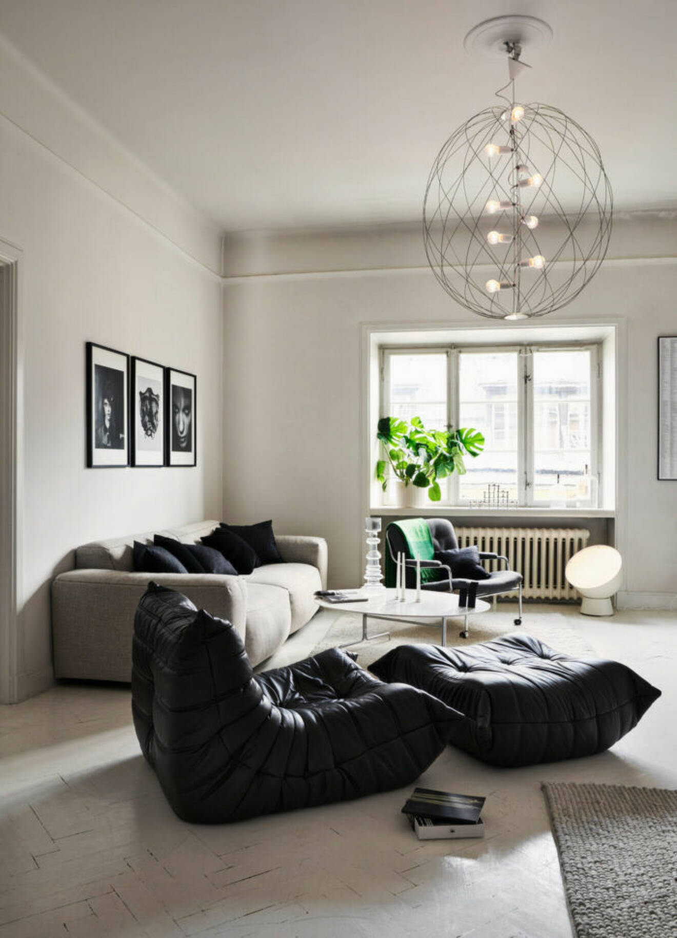 Svart fåtölj och fotpall i vardagsrummet hos modedesignern Lee Cotter i lägenheten i Stockholm