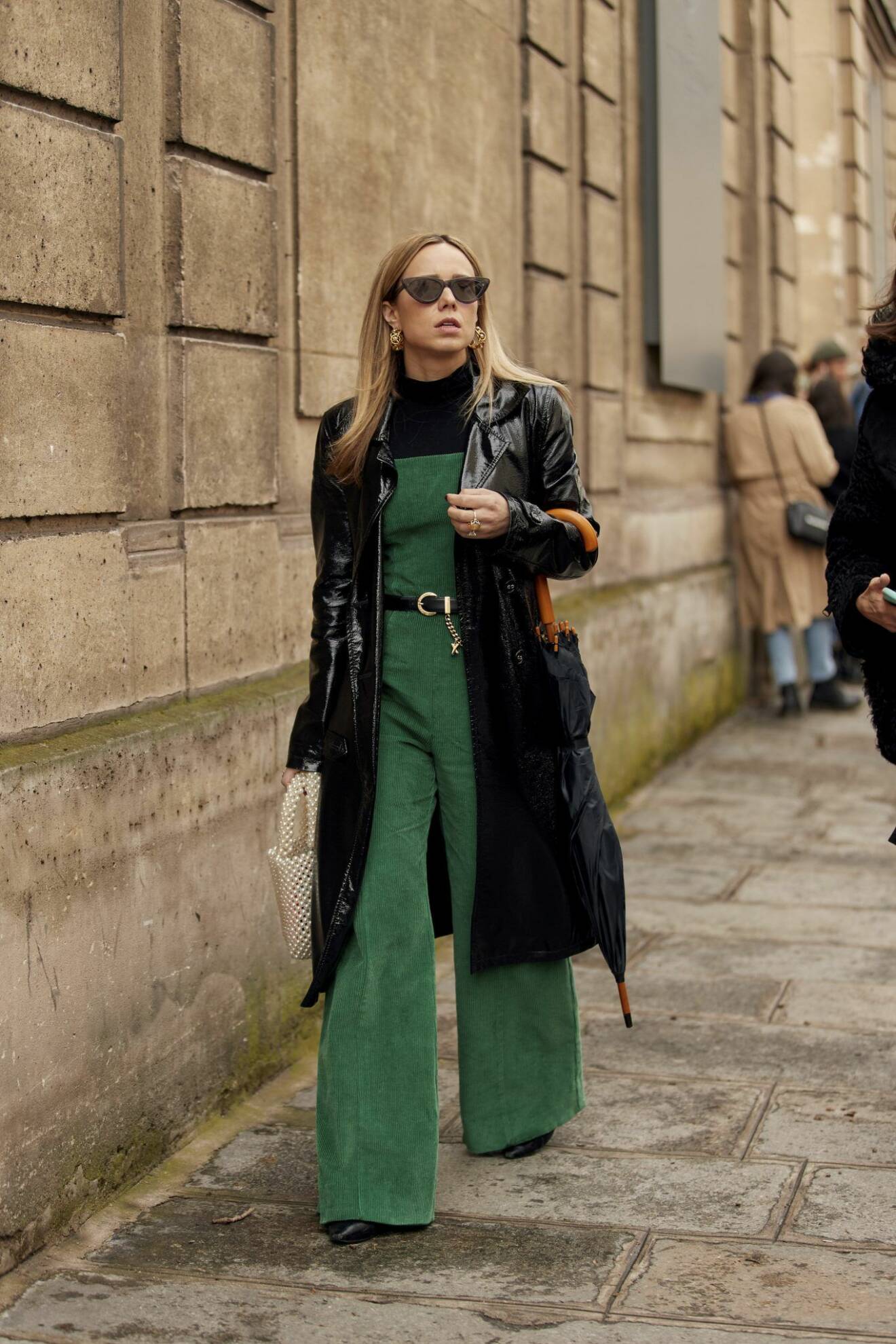 Svart kappa och grön jumpsuit Streetstyle Paris Fashion Week AW20.