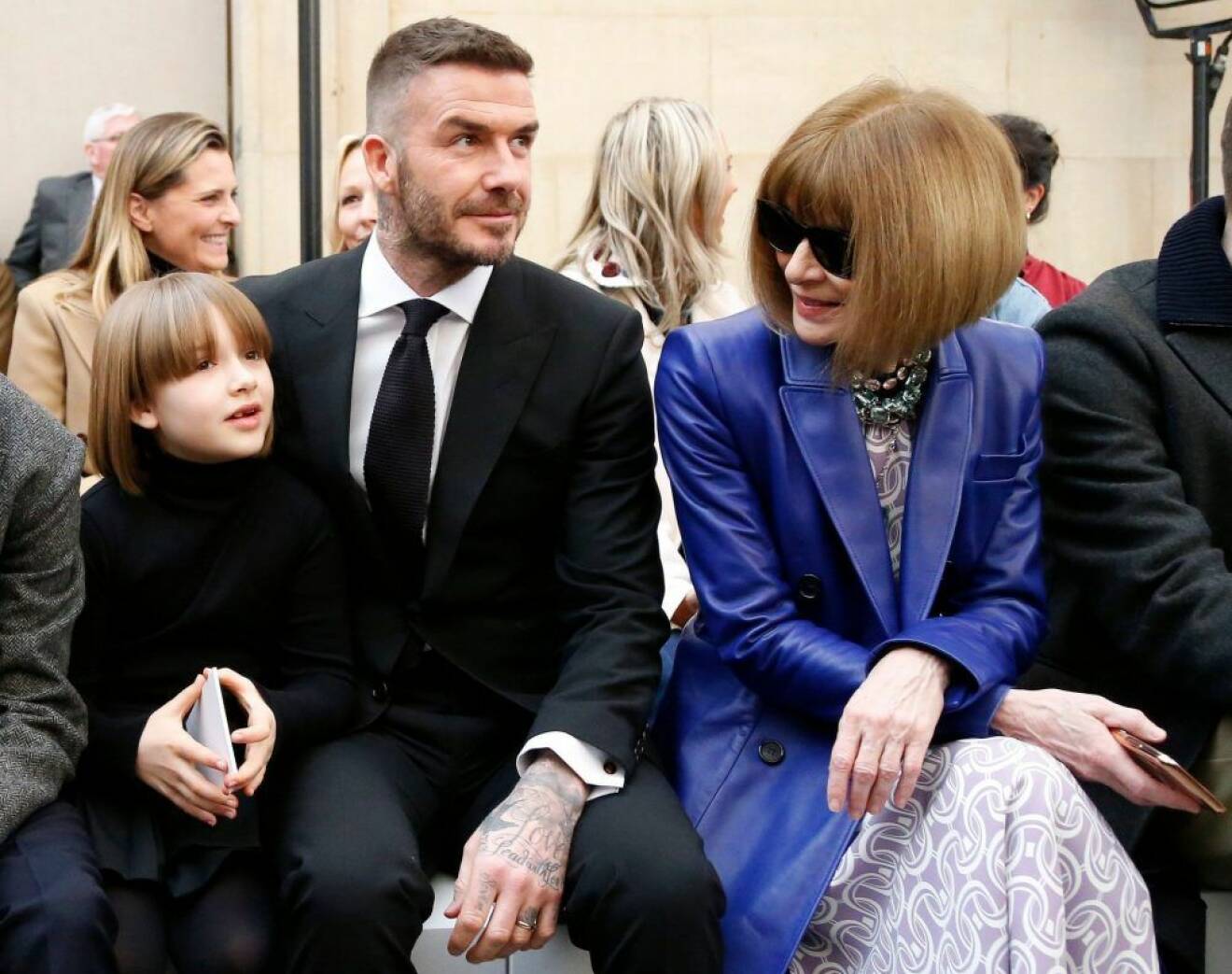Harper Beckham, David Beckham, Anna Wintour sitter på stolar