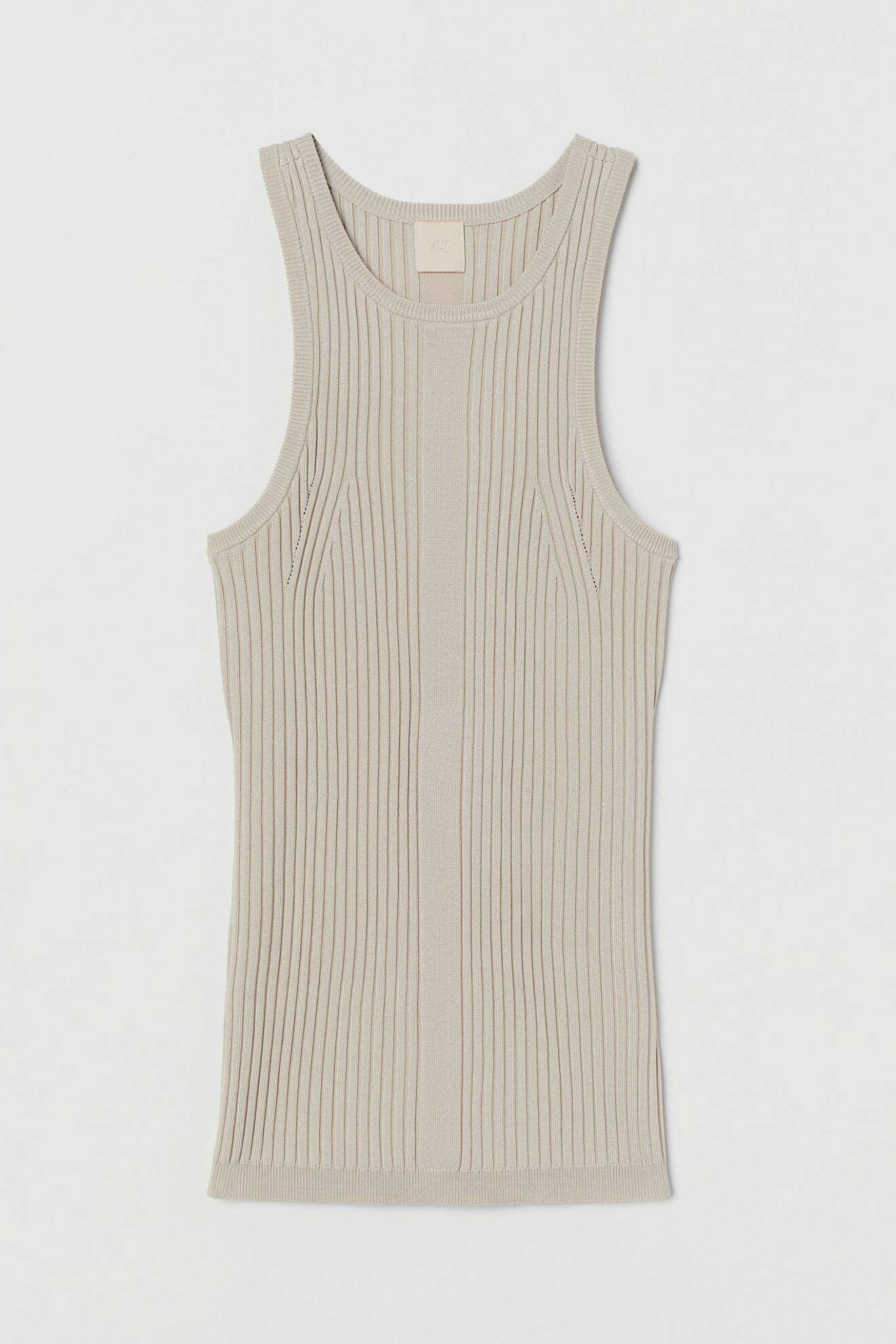 Bär ett ribb-stickat linne med hög hals under kavajen för en stilren look. Linne i beige från H&M.