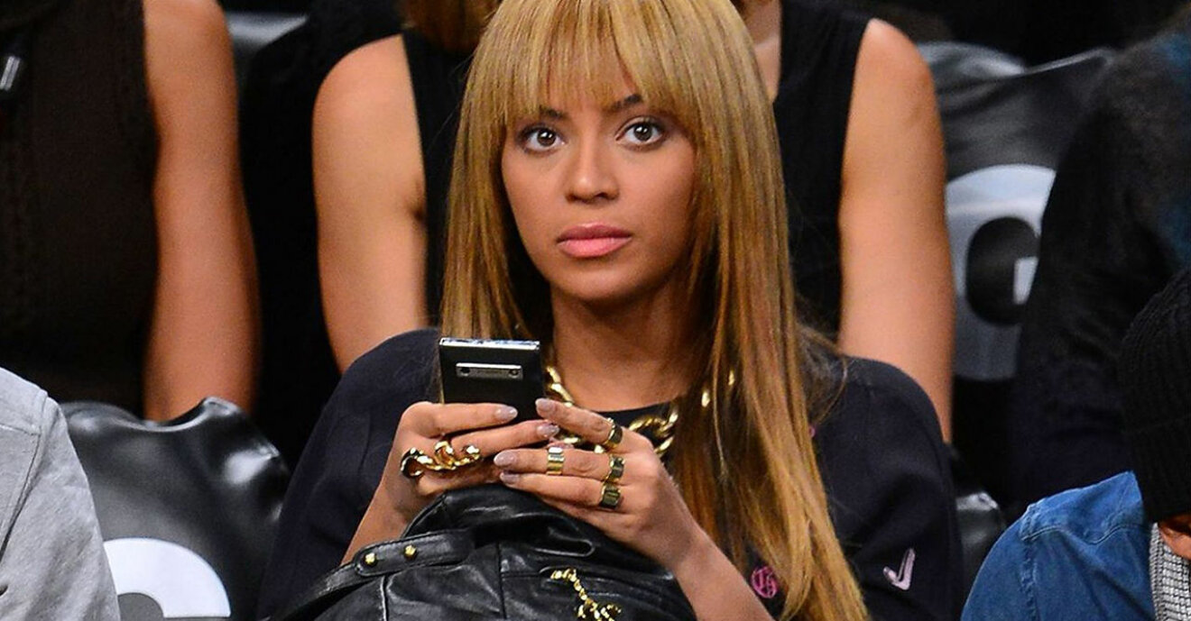 Beyonce sitter med sin telefon