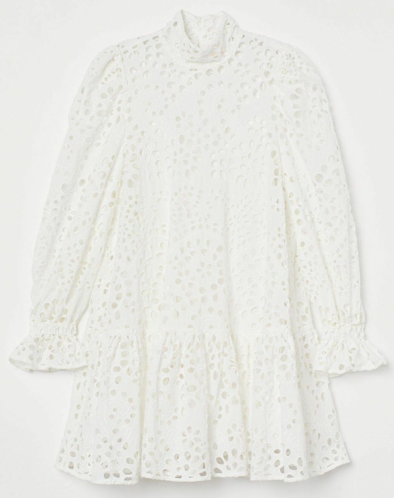 Voluminös klänning i vitt med dekorativa hålbroderier och smickrande volanger från hm.