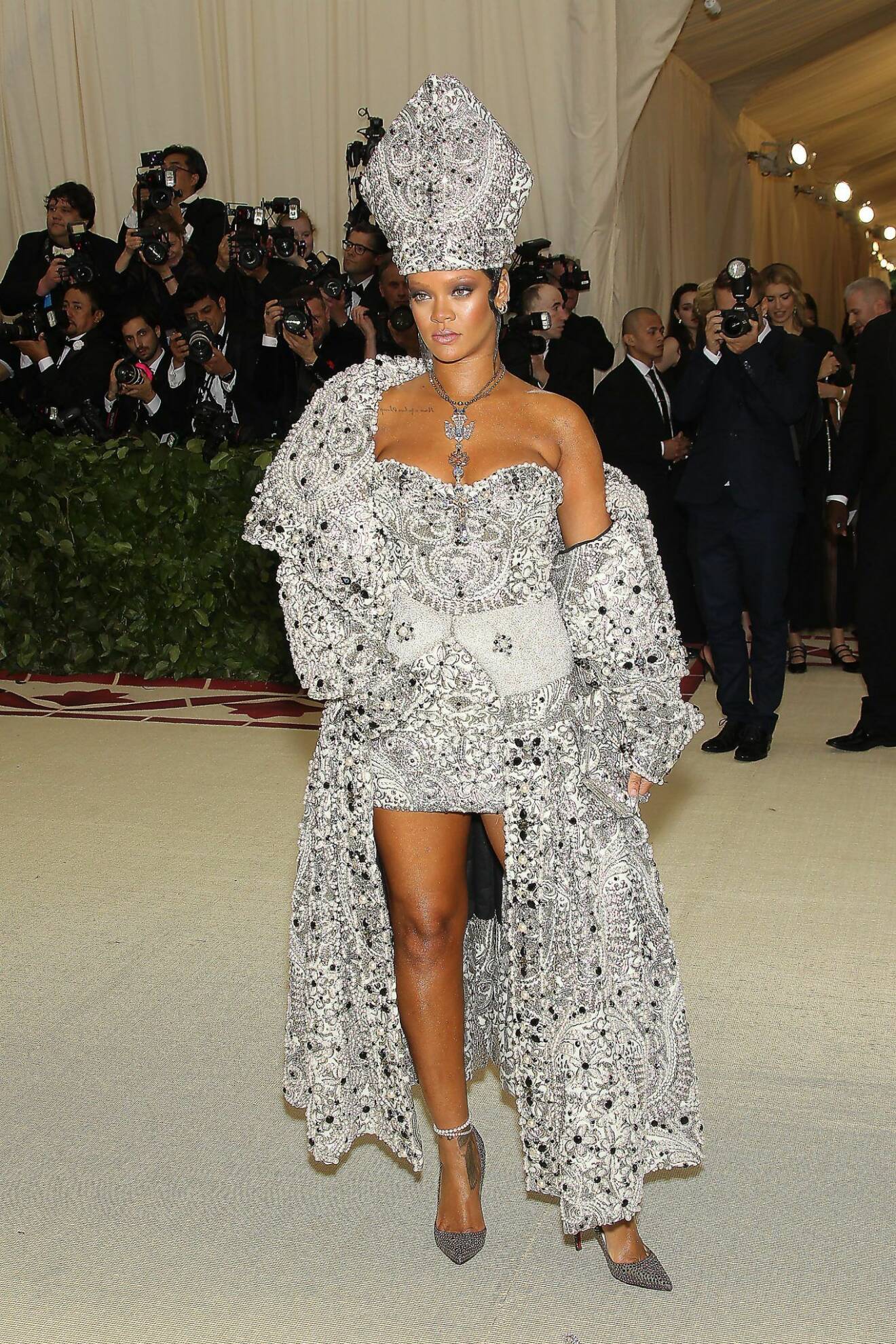 Rihanna poserar kaxigt i en dräkt som efterliknar påvens med en gigantisk mitra. 