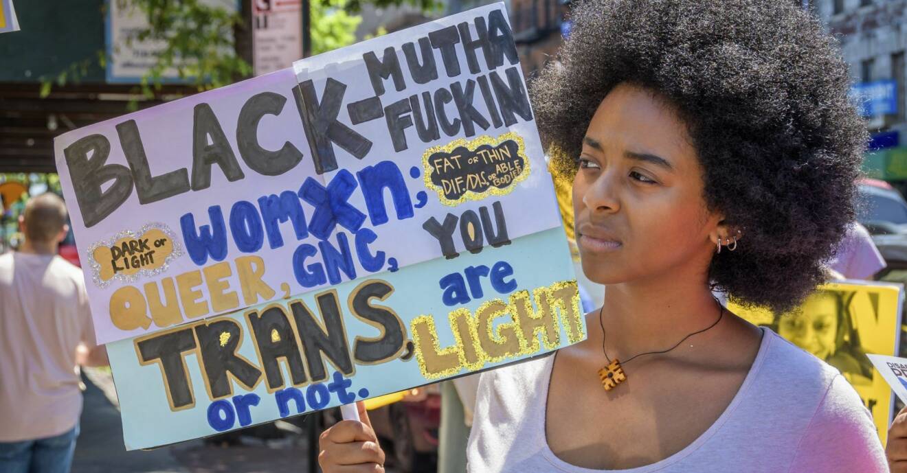 en kvinna håller upp en protestskylt