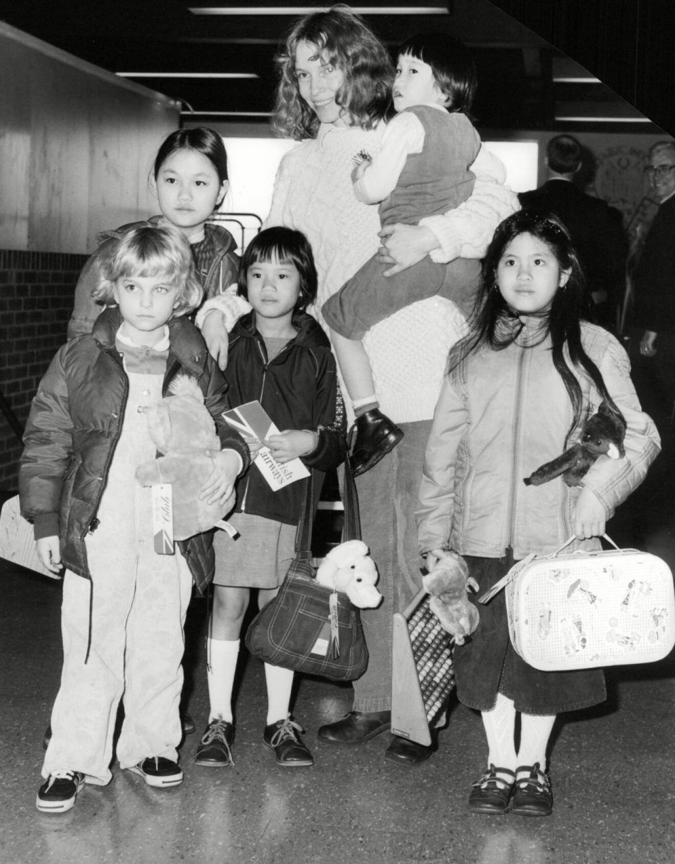 Mia Farrow med fem barn på en flygplats