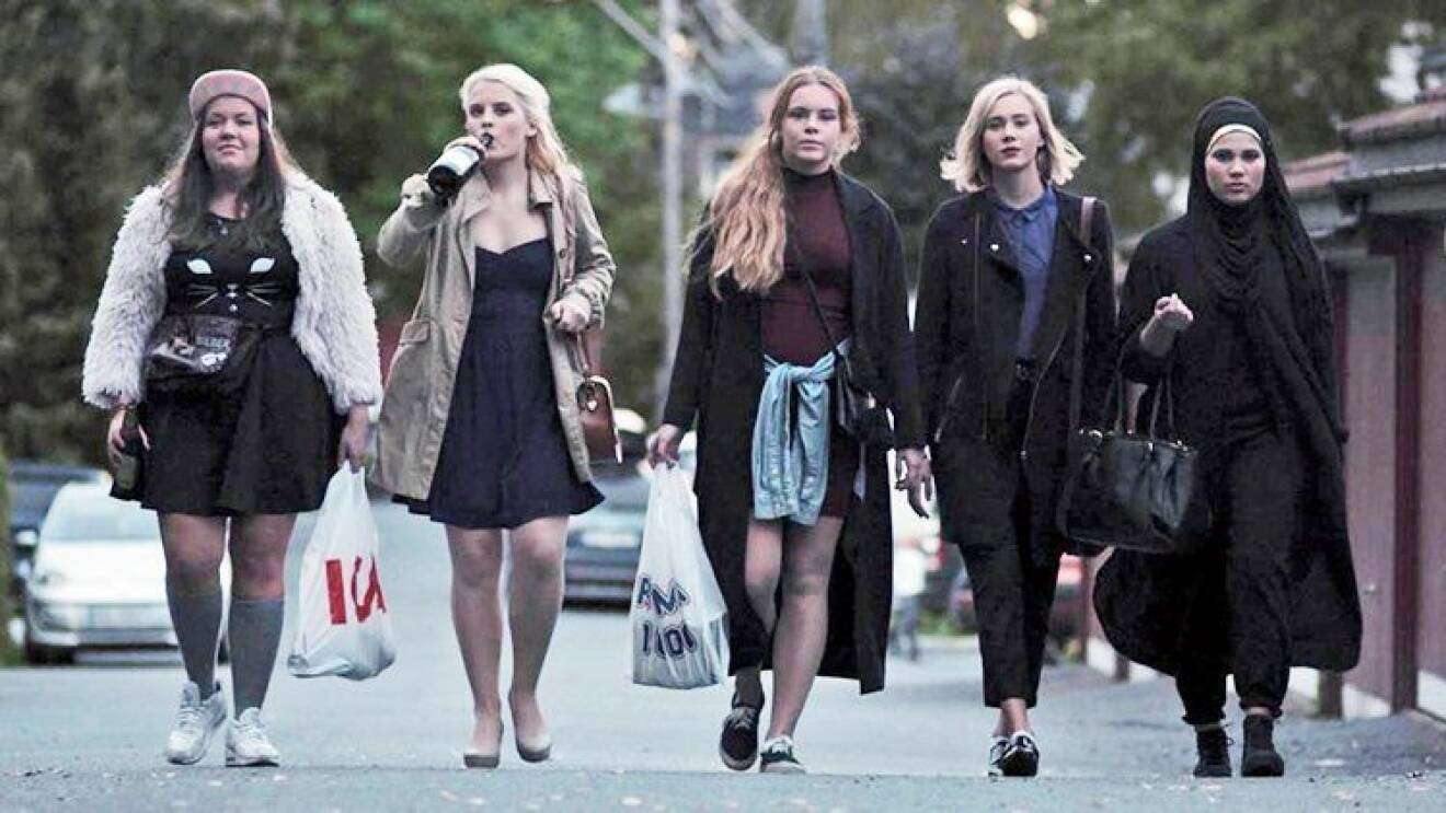 fem tjejer går i rad på en väg