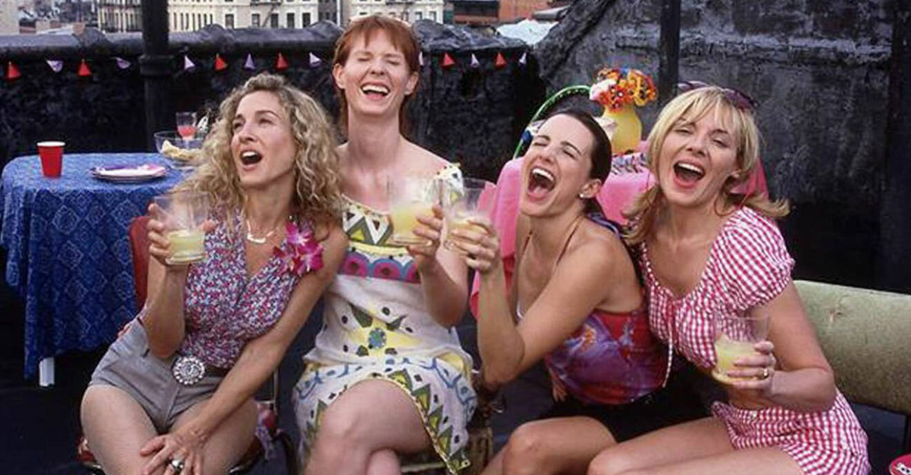 Carrie, Miranda, Charlotte och Samantha från Sex and the City har drinkar i handen och skrattar