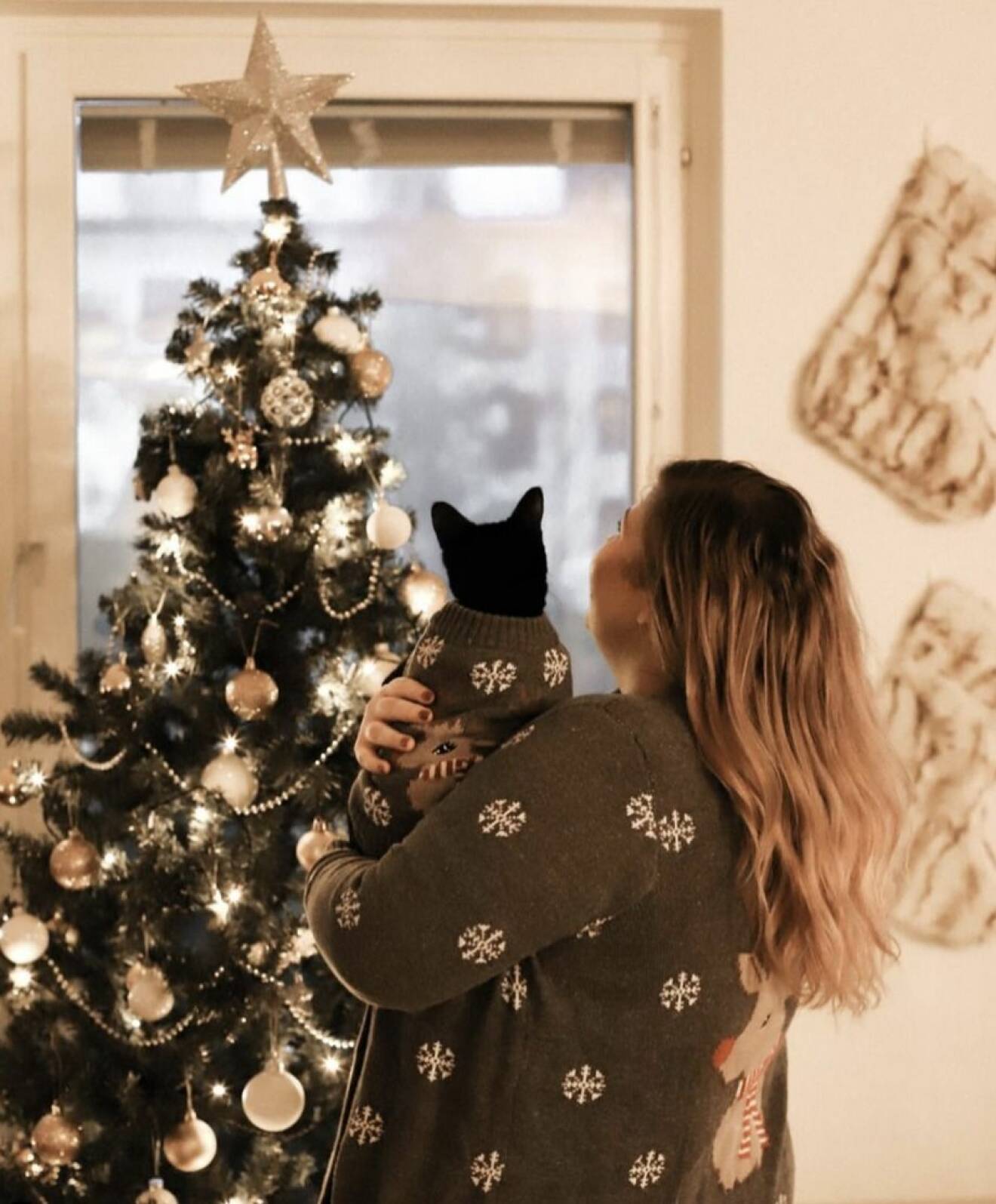 Linda-Marie Nilsson håller i en katt och tittar på sin julgran