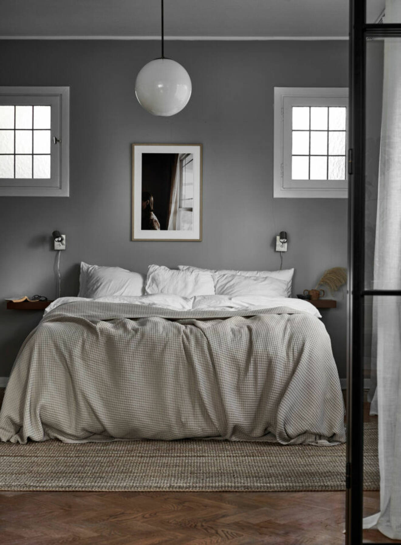 Stilrent sovrum med gråmålade väggar hos Julia och Emanuel Karlsten.