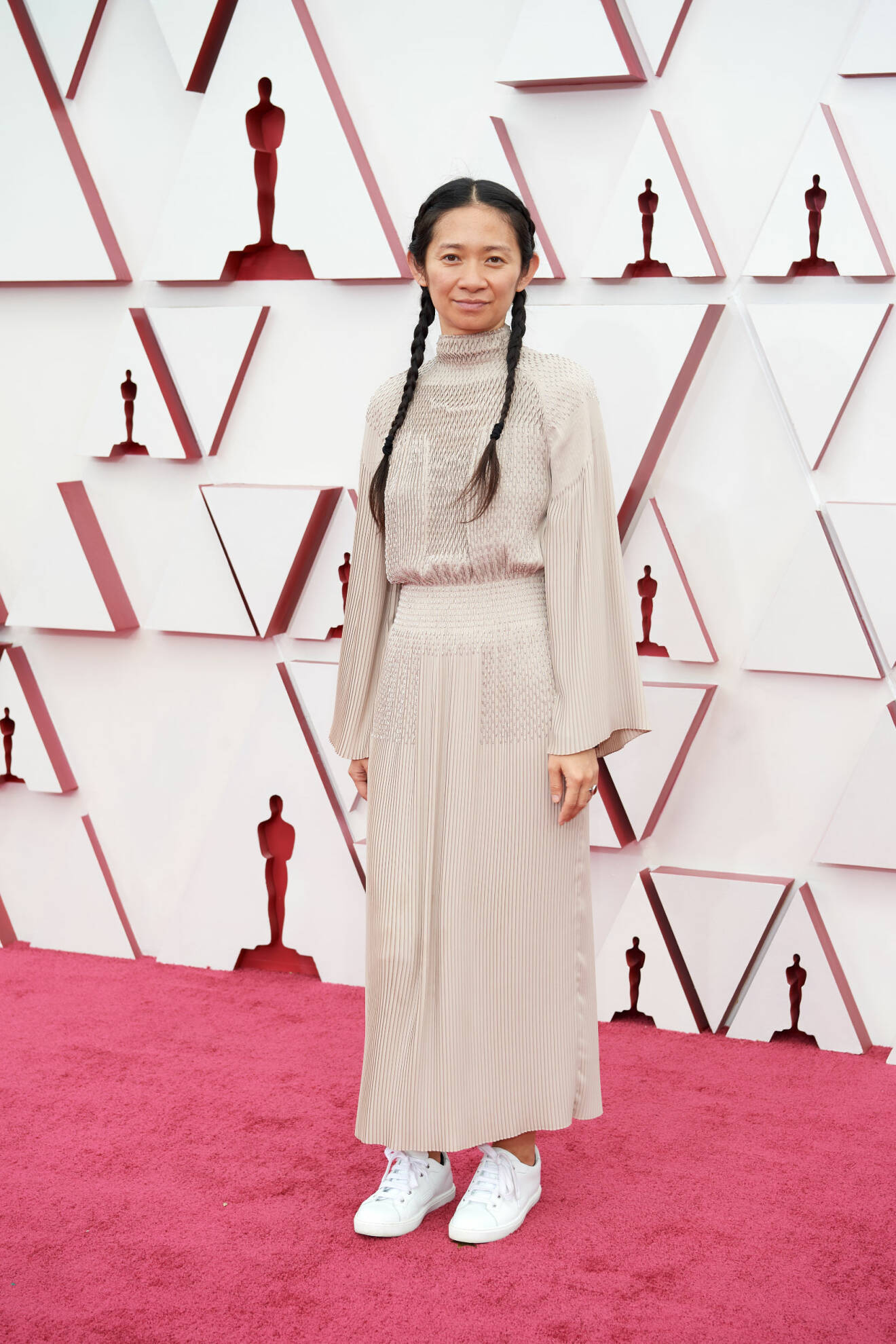 Chloé Zhao i beige klänning och vita sneakers