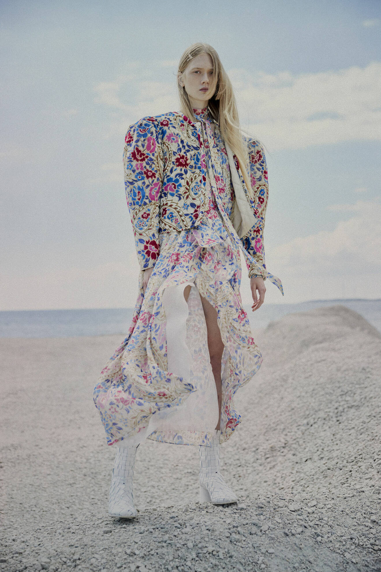 Modellen bär en blommig jacka och blommig klänning från Isabel Marant samt vita skor från Acne Studios