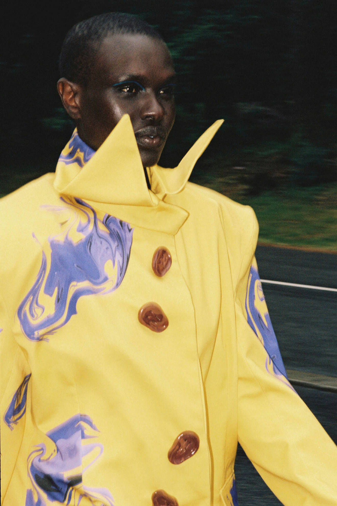 Modellen bär en gul jacka med lila detaljer från Niklas Gustavsson