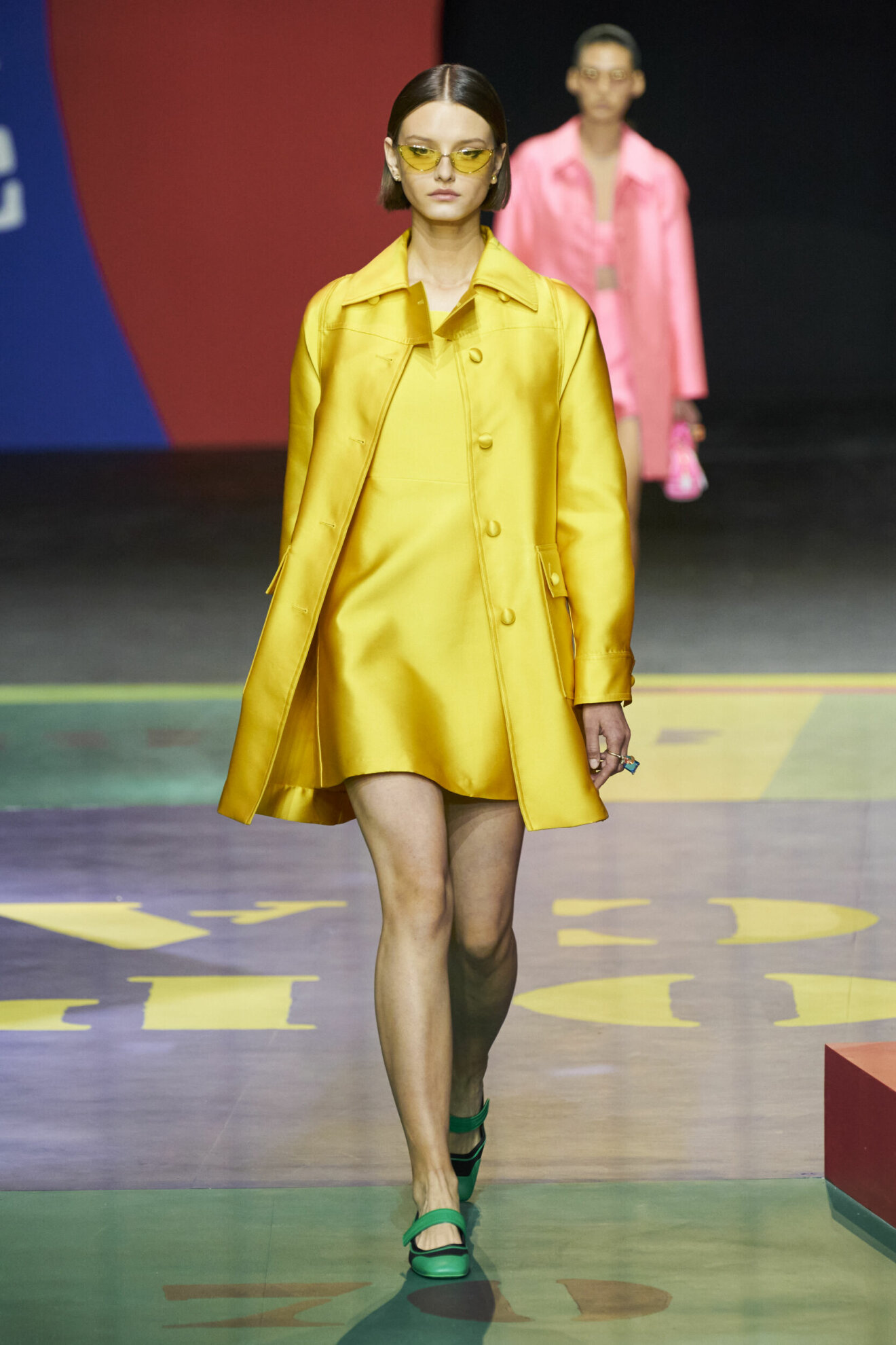 Gul silkesklänning och kappa med gula solglasögon från Dior.