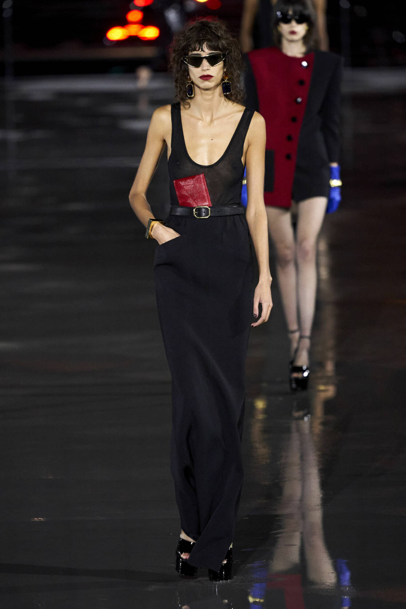 Lång svart klänning och röd plånbok från Saint Laurent.
