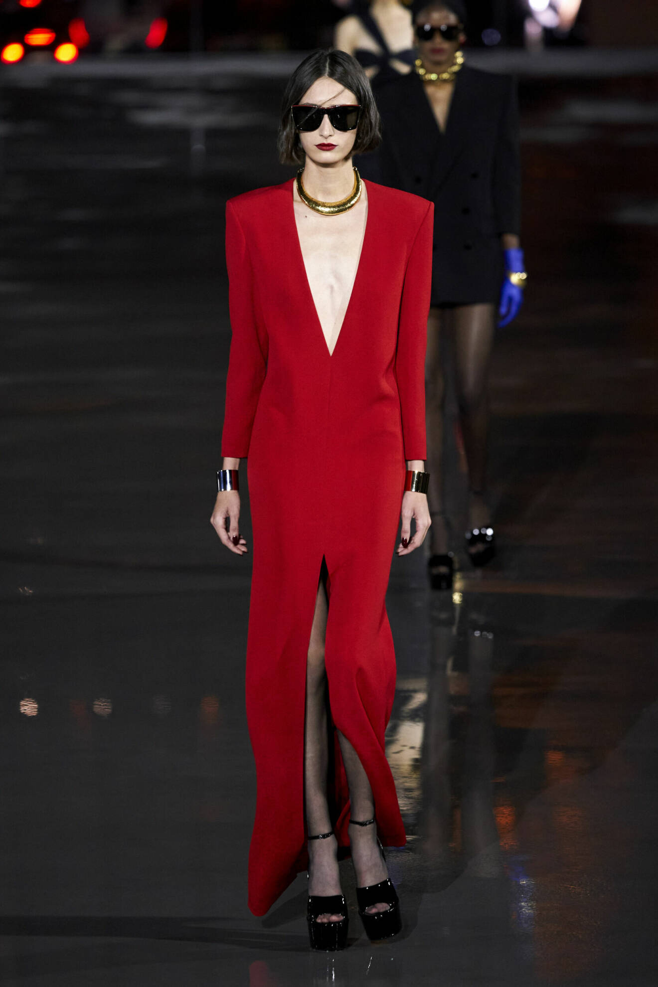Röd klänning med djup v-ringning och platåklackar från Saint Laurent.