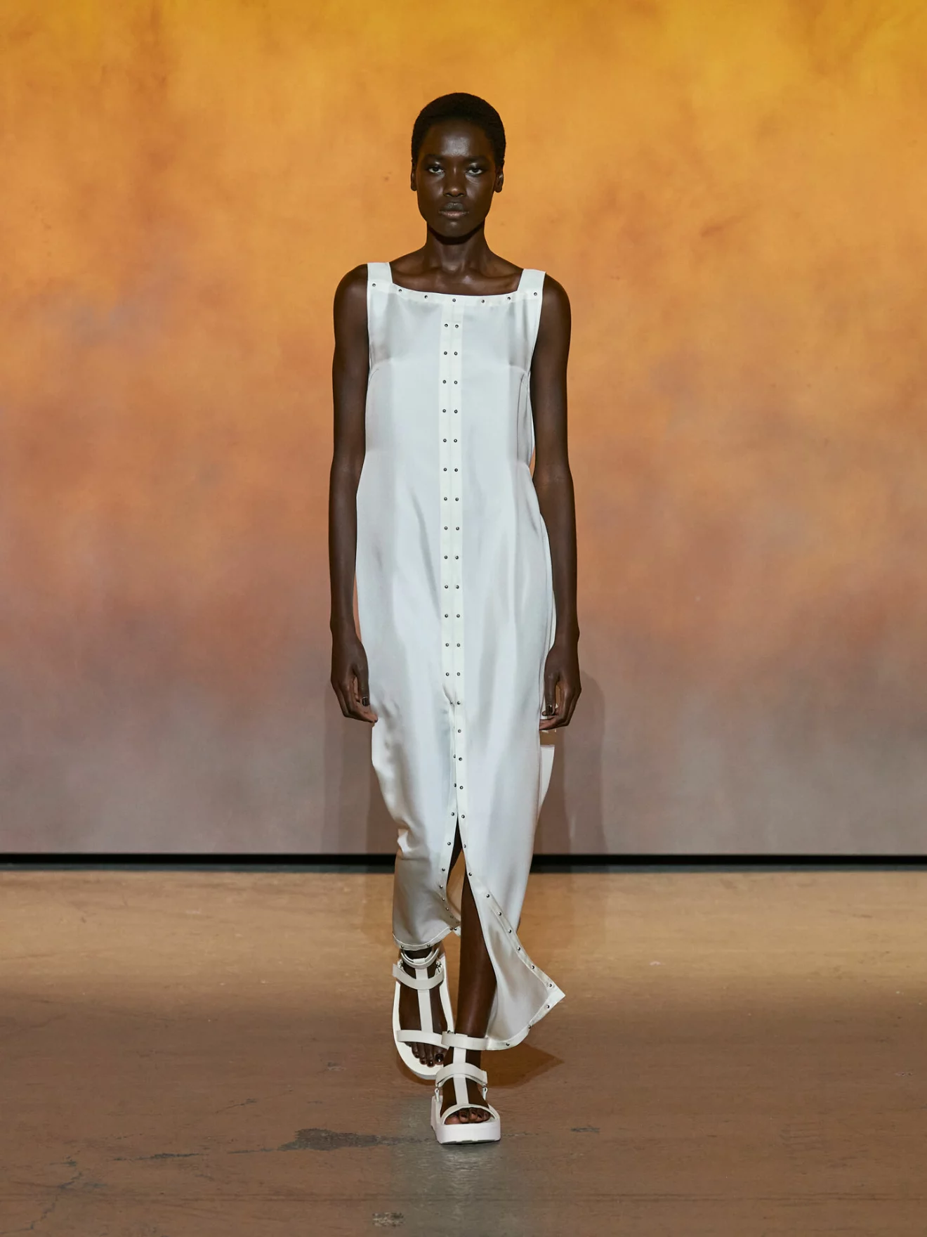 Lång vit klänning med vita sandaler från Hermès.