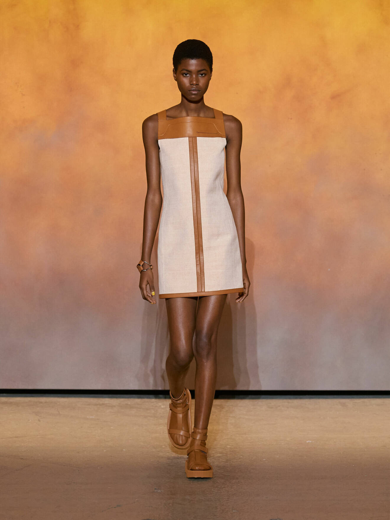 Kort klänning i beige med bruna skinndetaljer från Hermès.