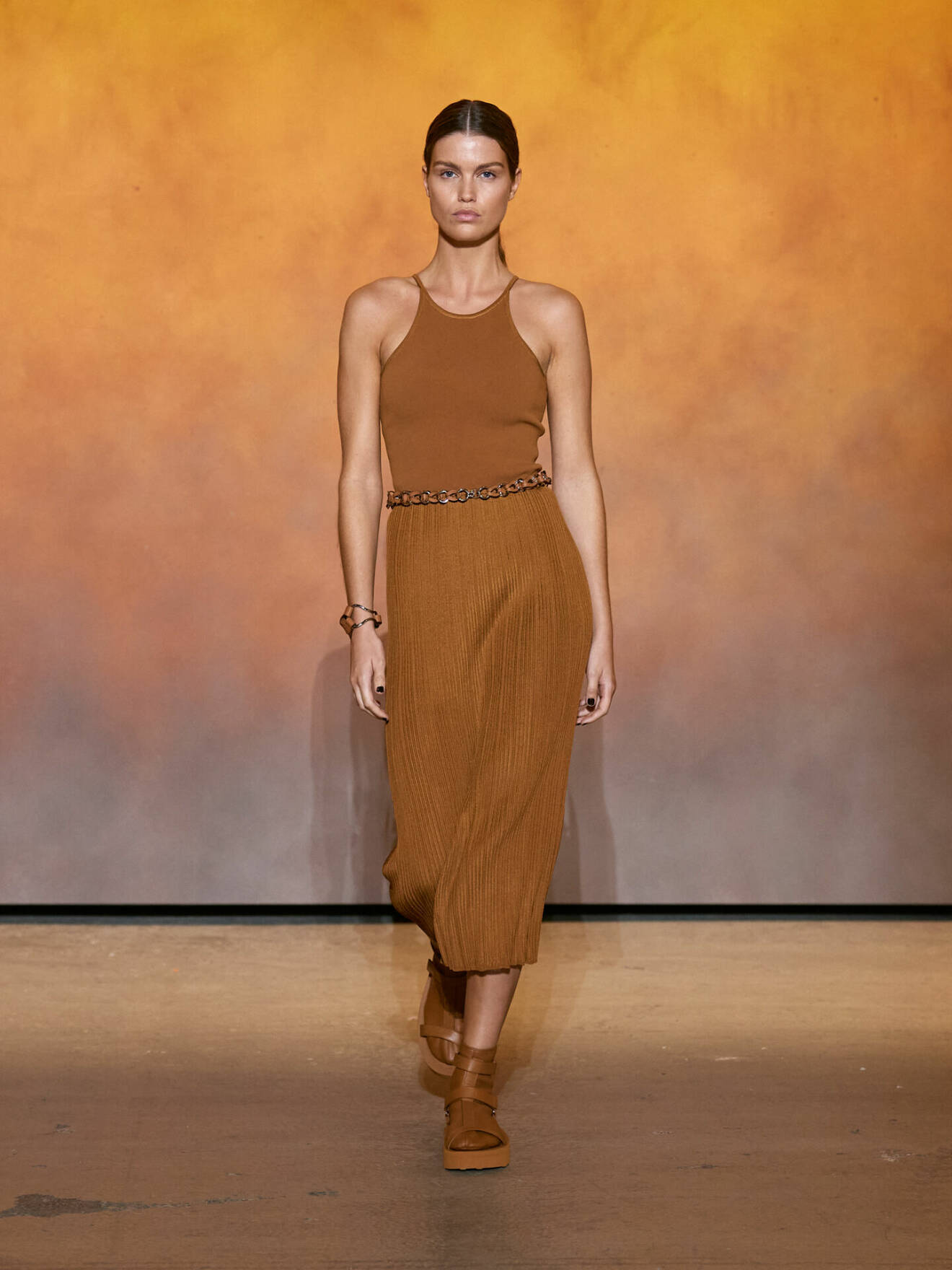 Plisserad kjol i brunt och bruna skinnskor från Hermès.