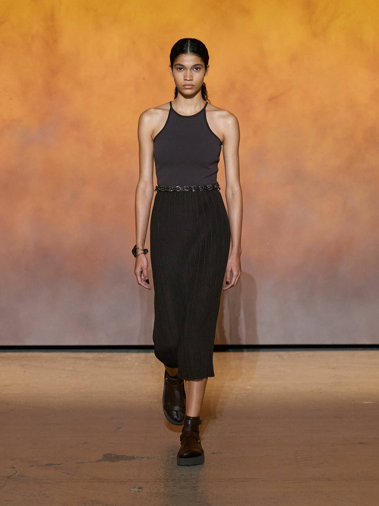 Mörkbrun plisserad kjol och maffigt armband från Hermès.