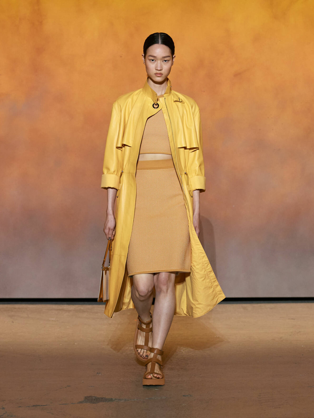 Lång gul kappa i skinn med ribbad pennkjol från Hermès.