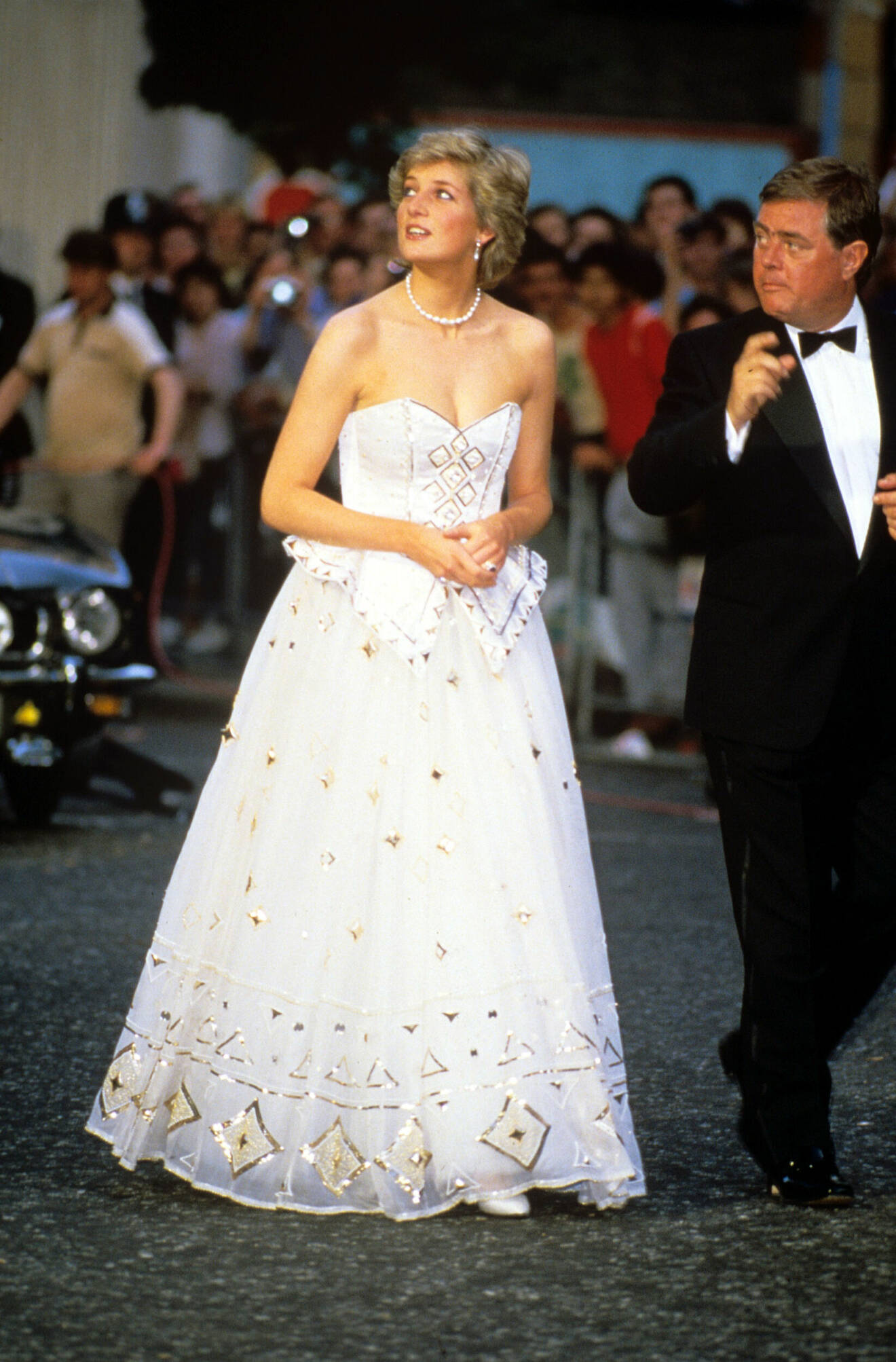 Diana i en vit klänning med gulddetaljer vid premiären av James Bondfilmen 1987.