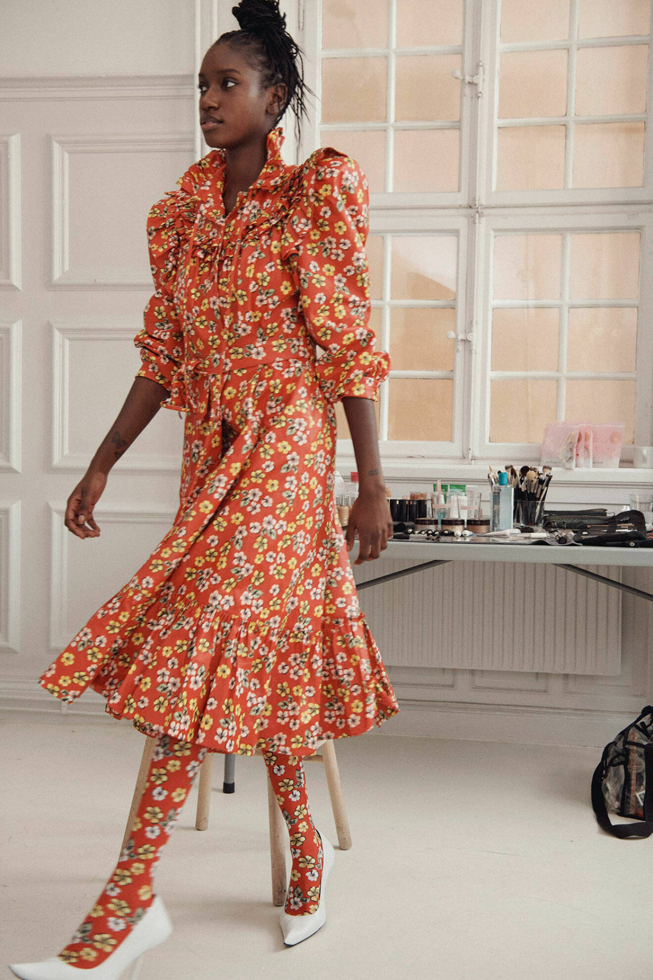 Amie bär en blommig klänning med matchande strumpbyxor från Balenciaga