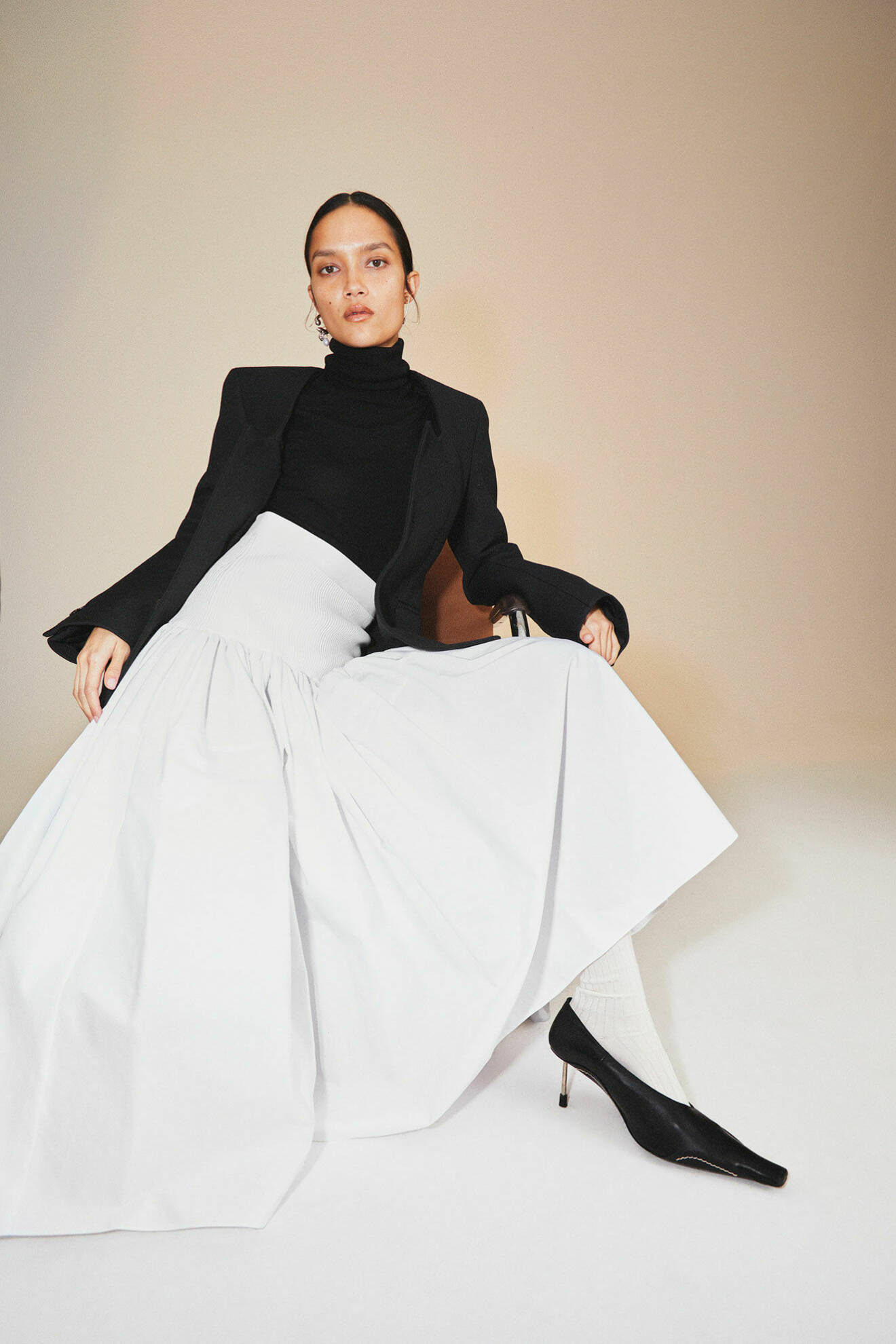 Modellen bär en svart kavaj från Bottega Veneta och en lång vit kjol från Alexander McQueen