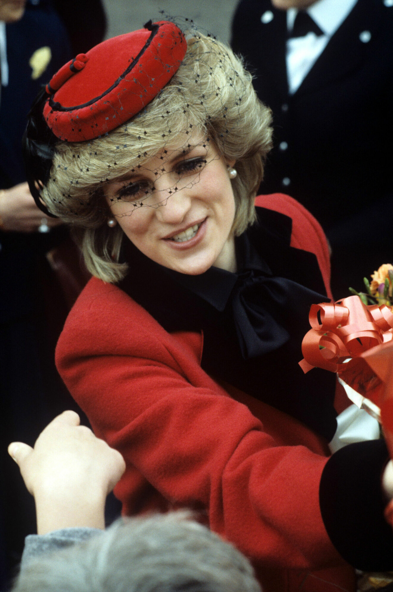Diana i Leicestershire 1984. Klädd i röd hatt, kappa och svart knytblus.