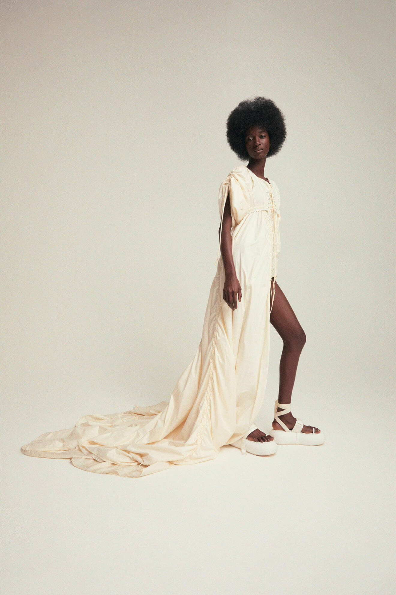 Modellen Shade bär en lång vit klänning från Lisa Helena Jacobsson