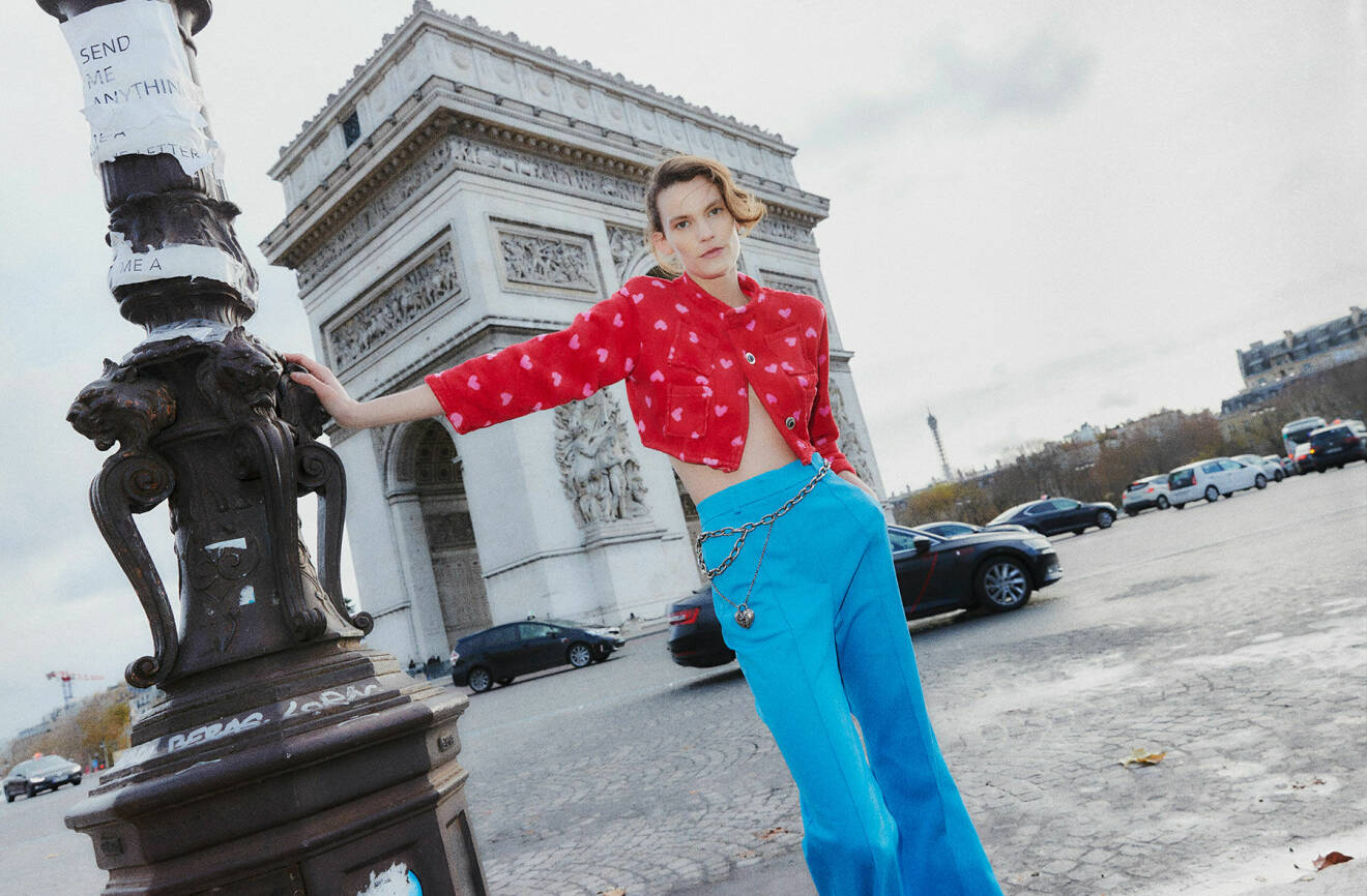 Lena har på sig en röd topp med rosa detaljer från Hodakova och blå byxor med pressveck från Sportmax