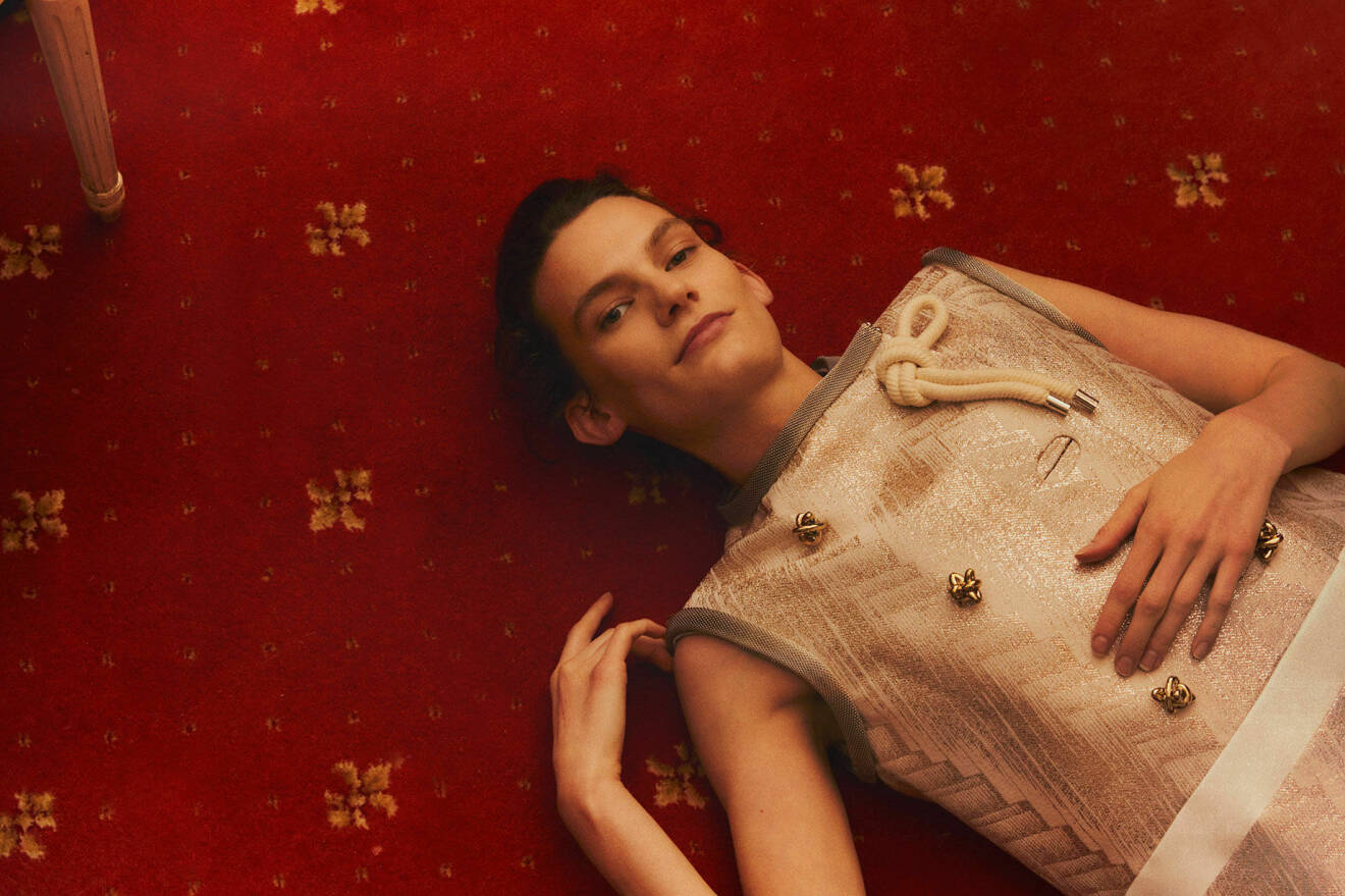 Modellen ligger på golvet i en klänning från Louis Vuitton