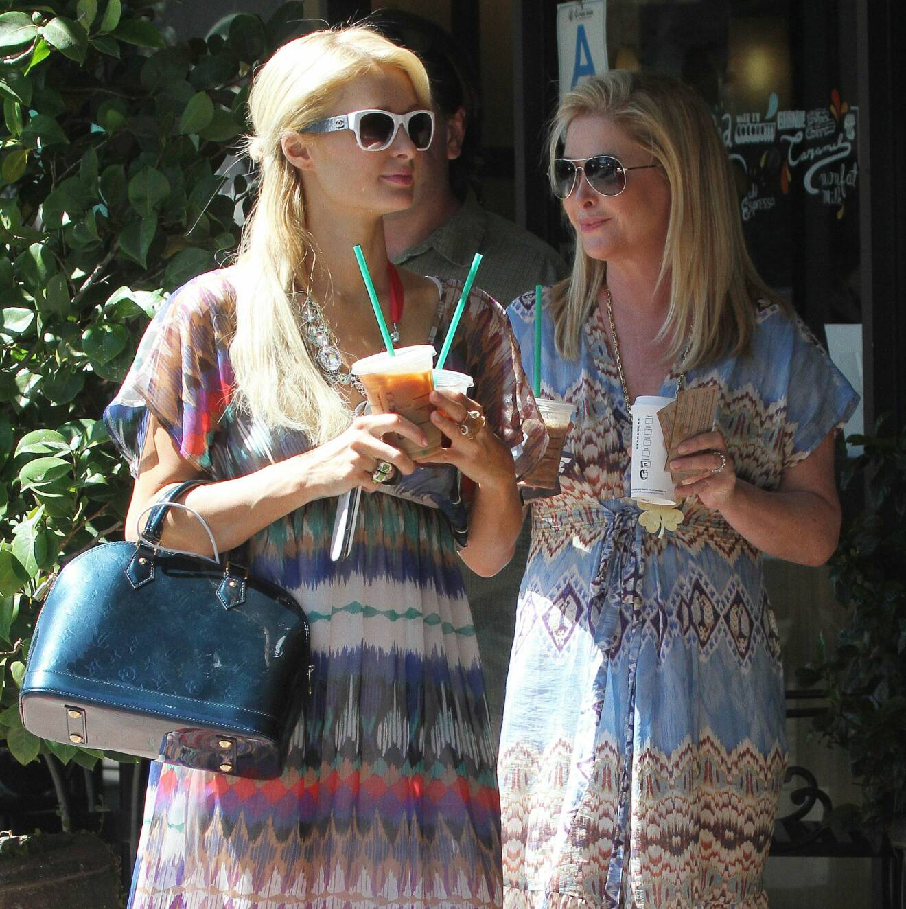 Paris Hilton med två kaffe i handen.