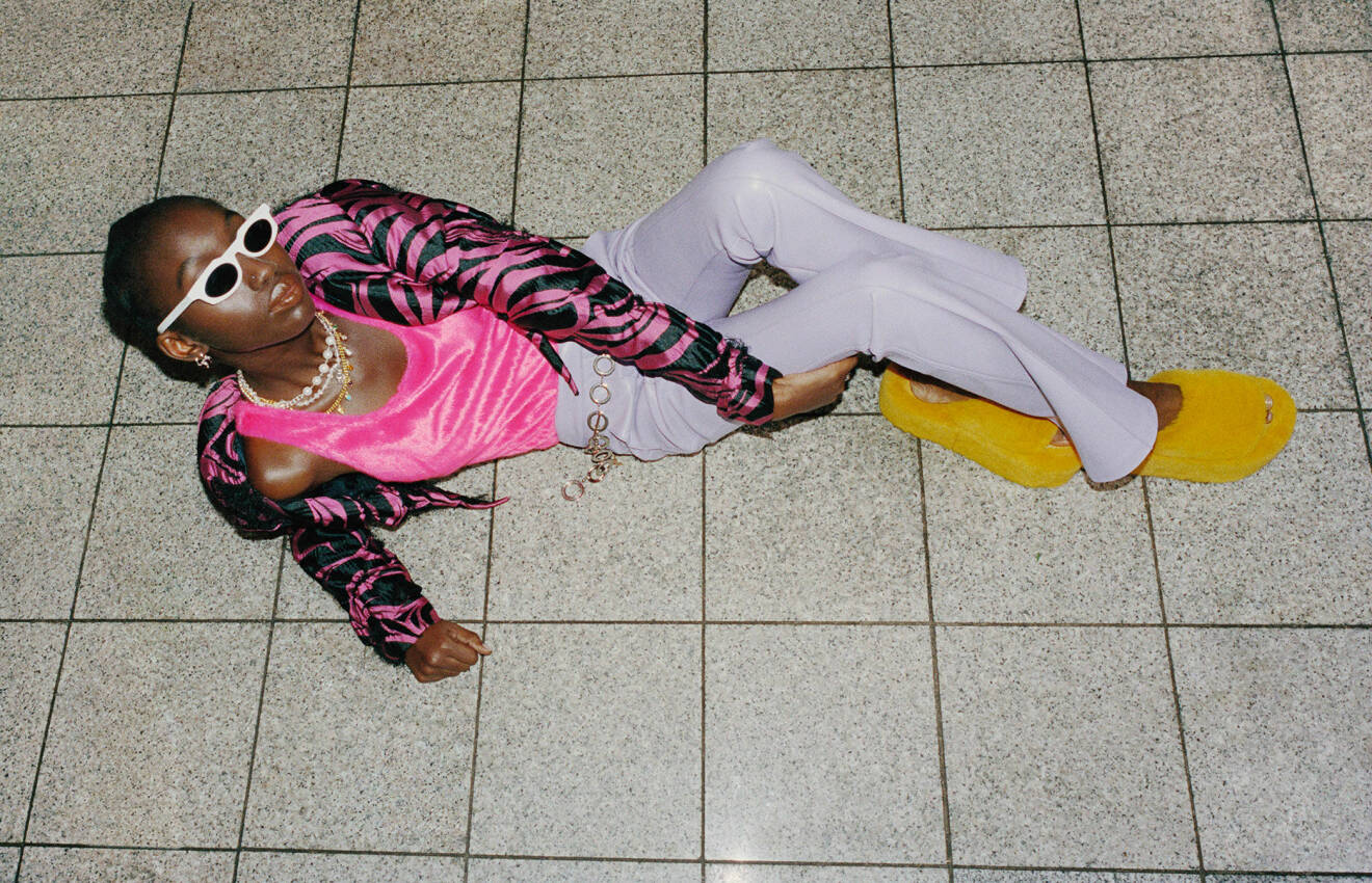 Modellen har på sig en rosa body med en jacka i svart och rosa zebra-mönster över samt lila byxor och gula skor