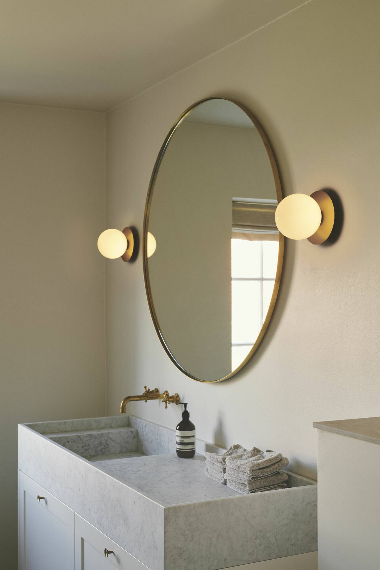 stilrent badrum med stor rund spegel