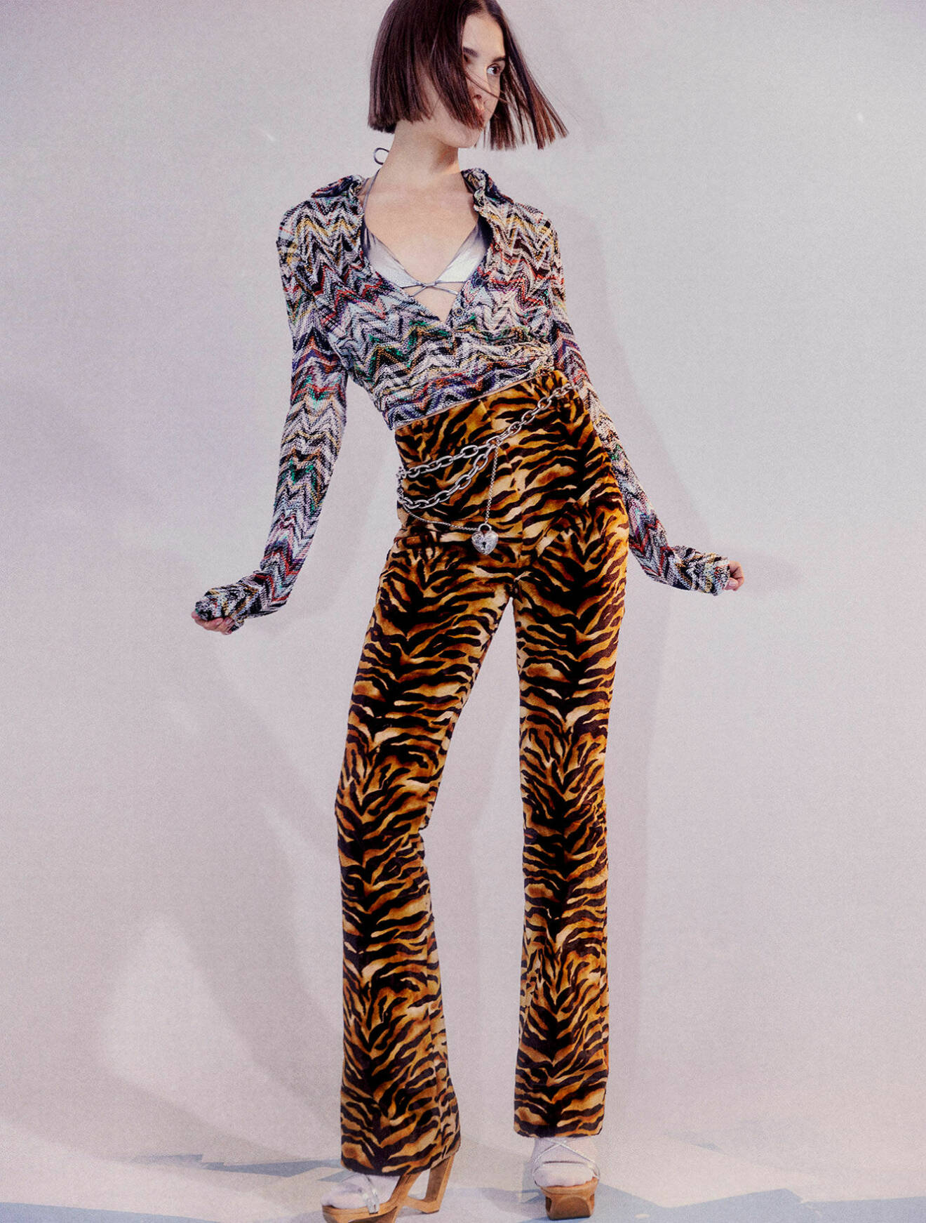 Modellen har på sig en mönstrad topp, silvrig bikinitopp och tigermönstrade byxor samt en magkedja