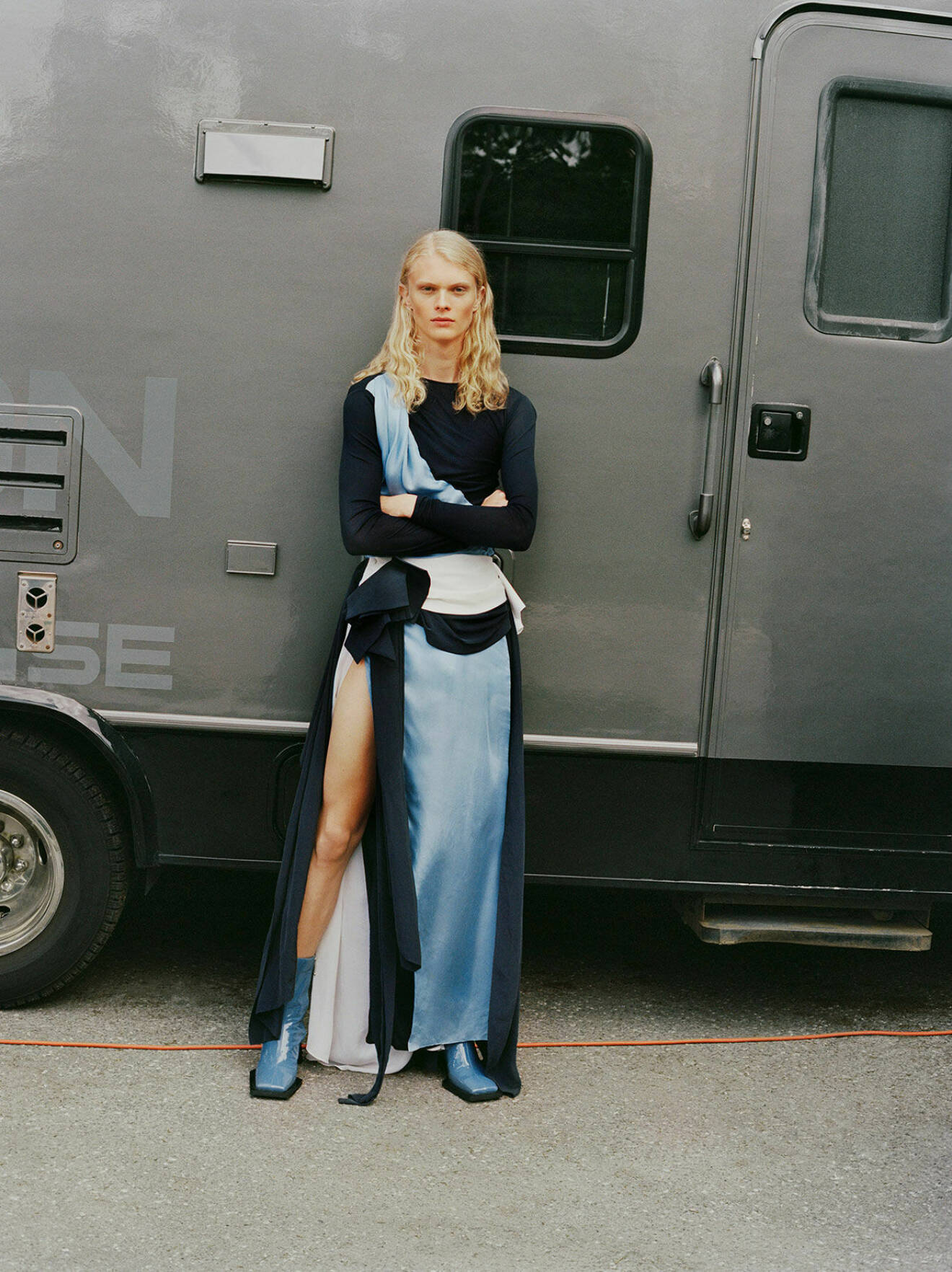 Fotomodellen Jako har på sig en långklänning i mörk- och ljusblått tillsammans med blåa boots